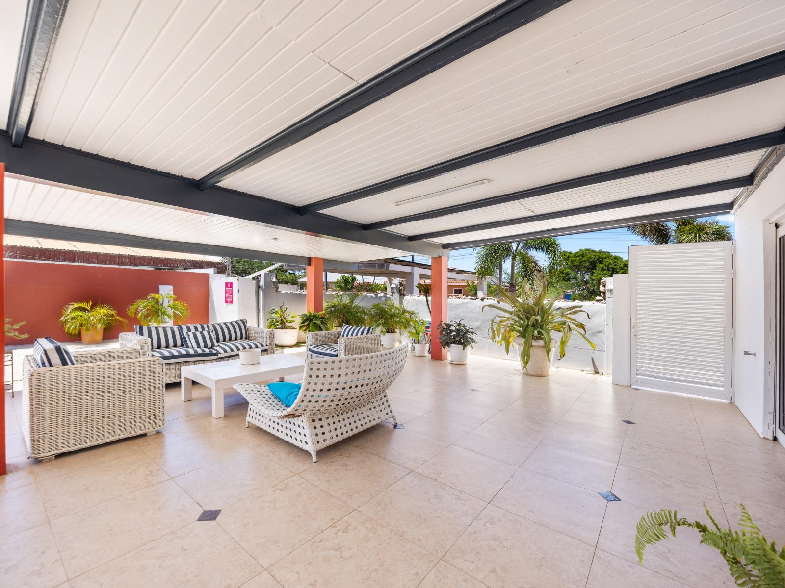 Unwind in the peaceful outdoor lounge area of this Oranjestad, Aruba home. - Sink into the cozy sofas, ideal for relaxing or diving into a good book. - Plenty of room for groups to come together and enjoy each other's company.