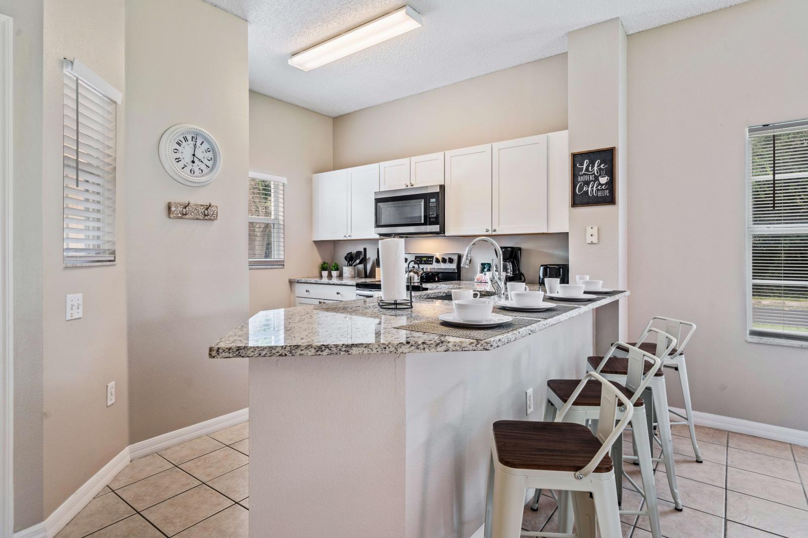 Kitchen offers counter space, making meal preparation a breeze - Enjoy casual dining at the convenient bar seating area, perfect for quick meals or morning coffee - Open layout seamlessly connects kitchen to the dining, creating a welcoming space