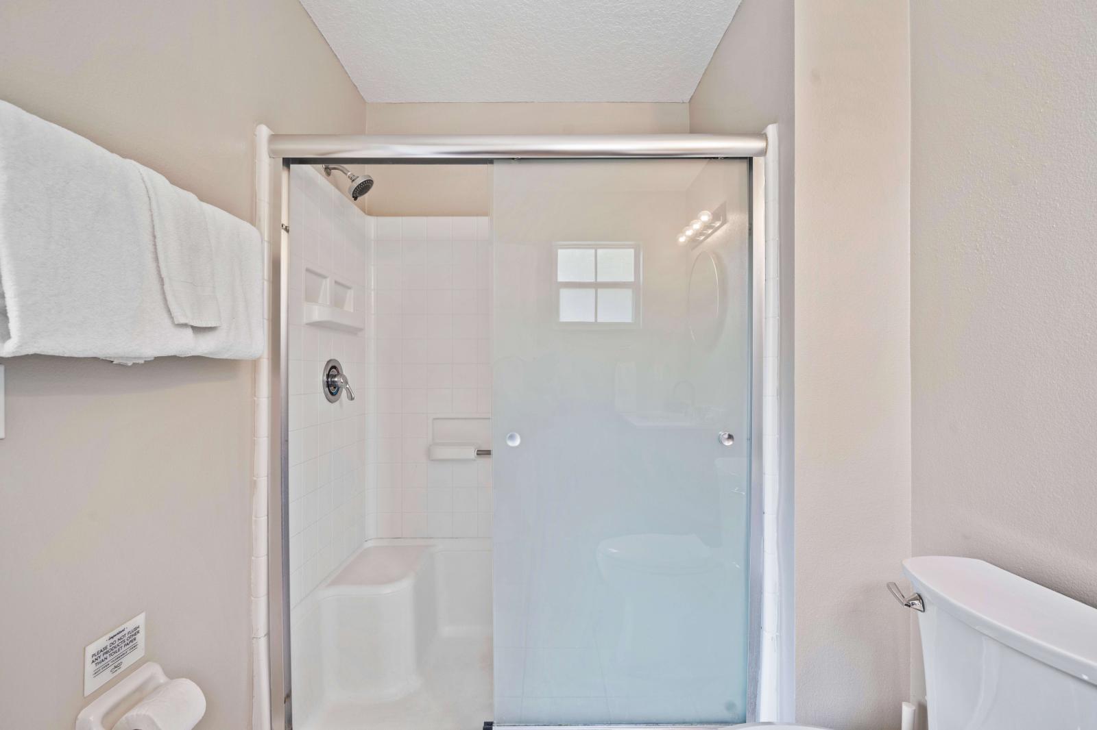 Bathroom features a modern design with a sleek glass-enclosed shower, offering style and functionality - Enjoy the convenience of a spacious shower area with contemporary fixtures - Fresh towels and essential toiletries are provided for convenience