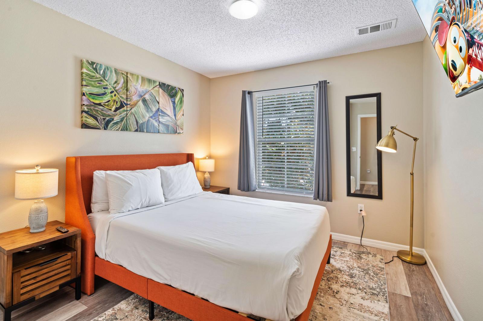 Bedroom with a comfortable queen size bed and crisp white linens, perfect for a restful night's sleep - Tasteful decor and complementary lighting fixtures - Natural light from window, highlighting the neutral tones and creating serene atmosphere