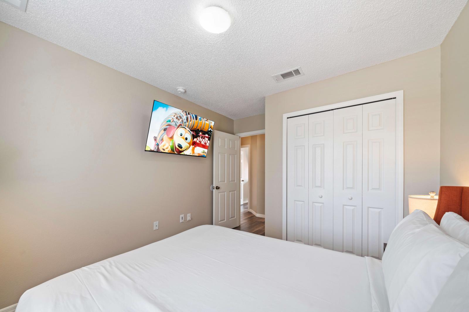 Relax in this inviting bedroom, furnished with a comfortable queen size bed - Equipped with a large flat-screen TV, perfect for unwinding with your favorite shows or movies - Plenty of closet space, allowing you to keep your belongings organized