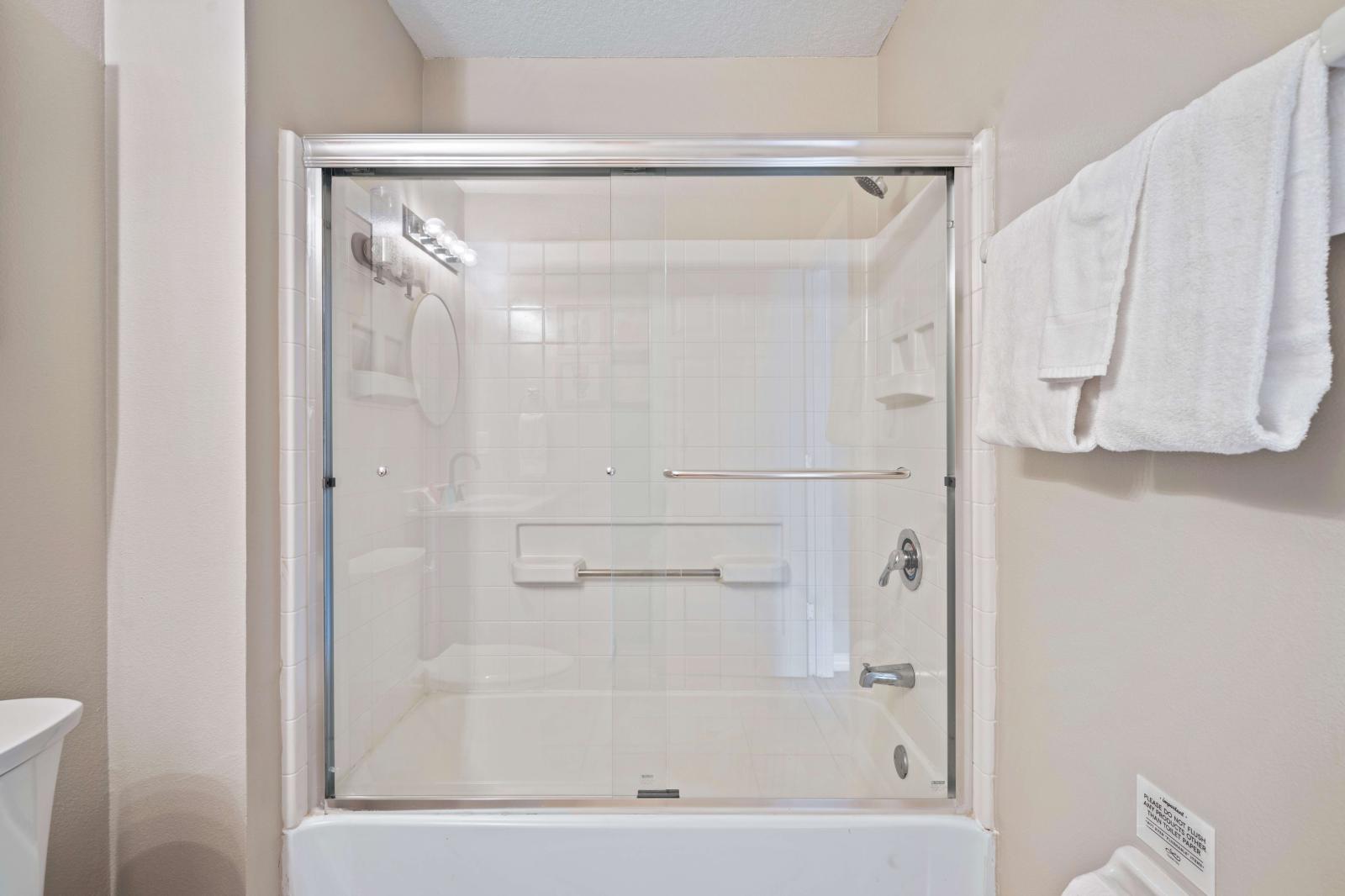 Enjoy a relaxing shower in this clean and well-maintained bathroom, featuring a glass-enclosed shower - Stocked with fresh towels and essential toiletries, ensuring a comfortable experience - A serene space to unwind and refresh during your stay