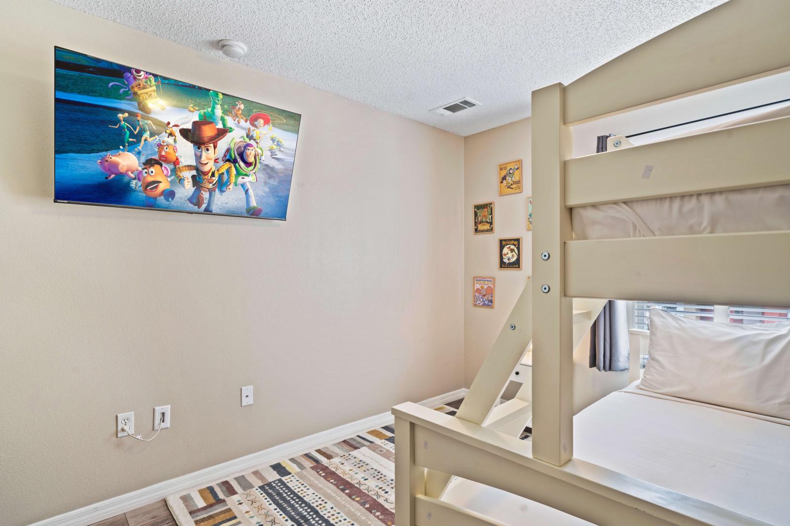 Enjoy movie nights or cartoons in this cozy bedroom, equipped with a large flat-screen TV - The bunk bed setup provides plenty of sleeping space - Bright and cheerful, this room is designed for a fun and comfortable stay