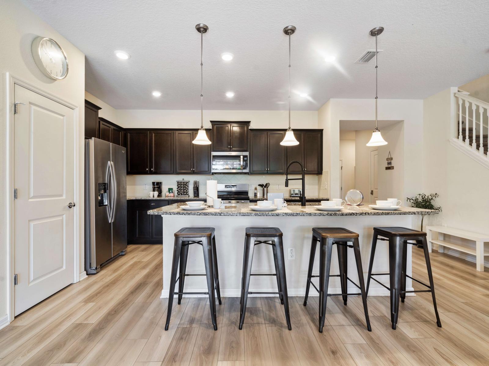 Sleek kitchen featuring granite countertops, stainless steel appliances, and cabinet storage - Open floor plan, seamlessly connecting to the living area - Large island with seating provides a perfect spot for casual dining and entertaining