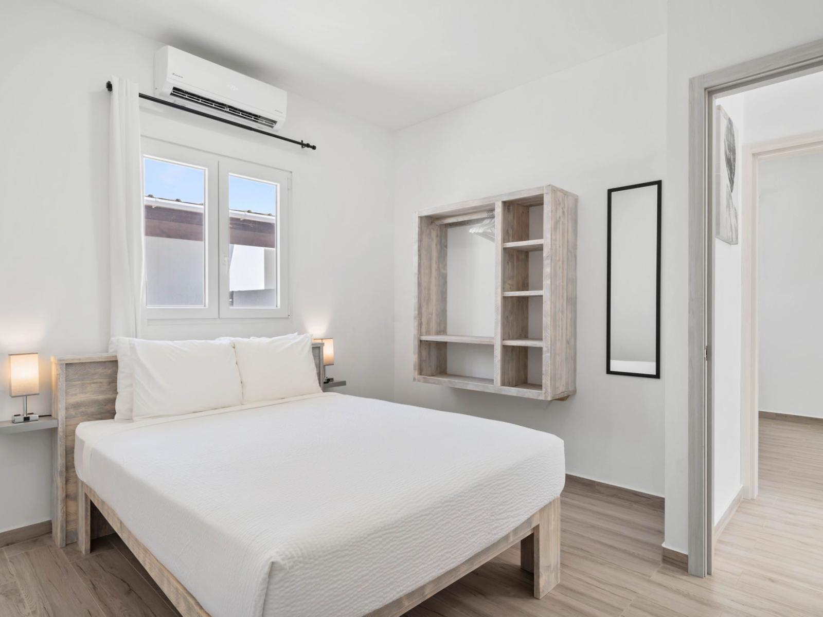 - Cozy bedroom with a queen-size bed, dressed in crisp white linens for a serene, restful feel - Wall-mounted open wardrobe provide practical storage with a minimalist aesthetic - Soft lighting and natural light create a bright yet calming atmosphere