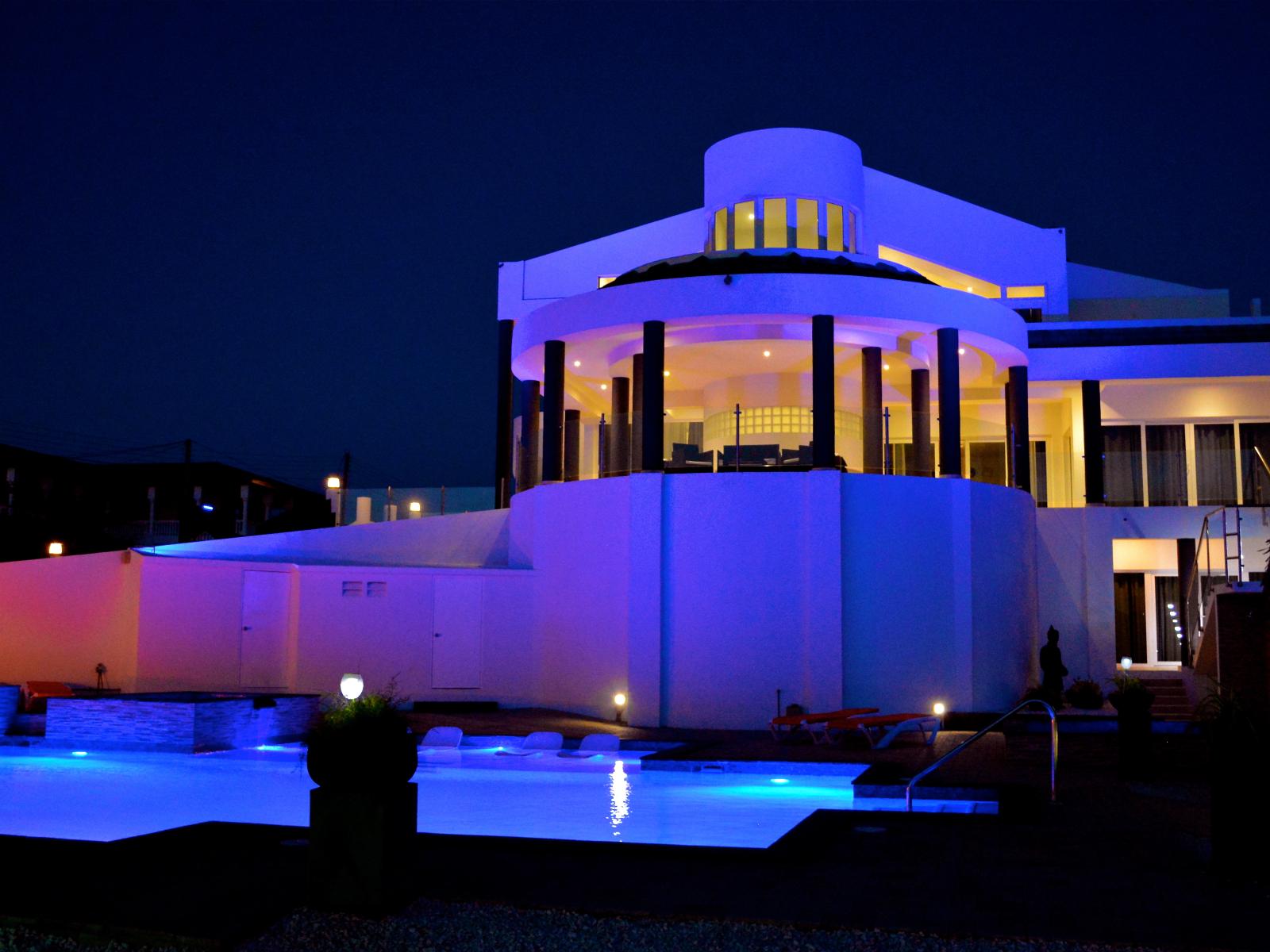 Spectacular lit up view of the home from the backyard at night