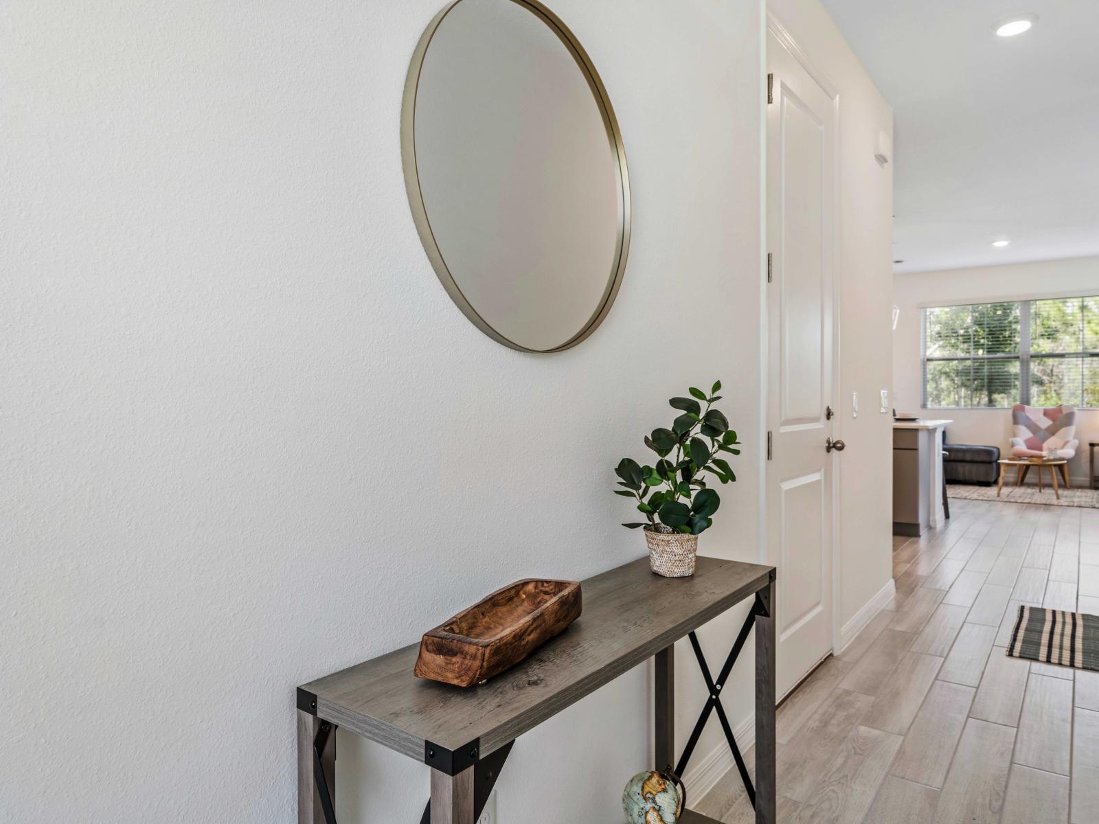 Welcoming entryway with a sleek console table, step into comfort and style - Decorative mirror and a touch of greenery, be enchanted as you cross the threshold into inviting sanctuary - Leads into the open and inviting living area