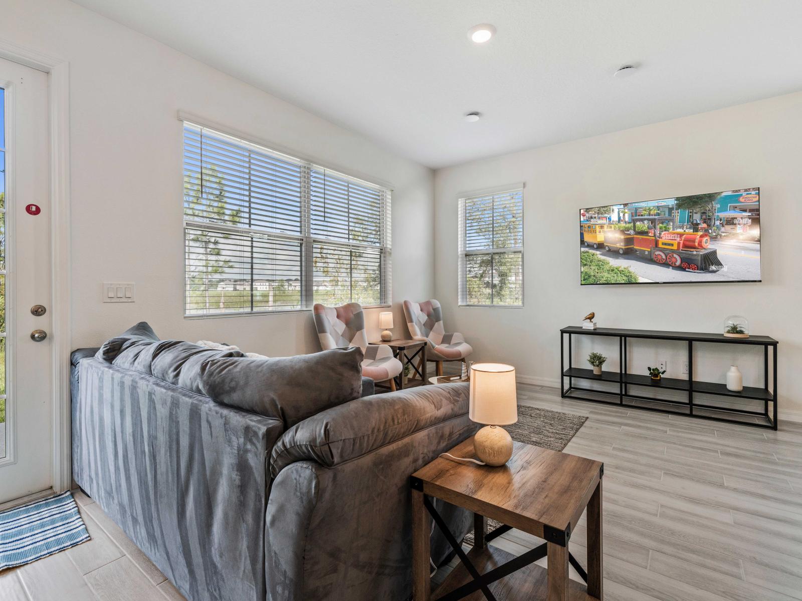 Enjoy movie nights or quiet evenings in comfortable and stylish living area. - Large windows offering plenty of natural light and outdoor views - Wall-mounted TV and stylish decor create a welcoming space