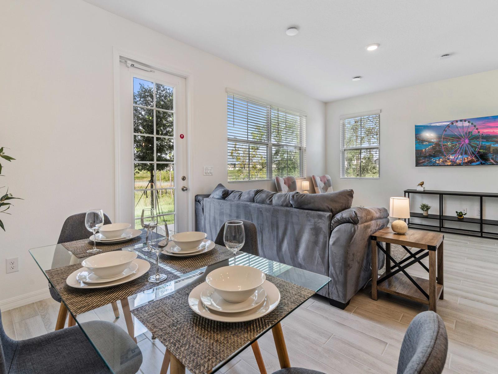 Gather around the table and share laughter and delicious food in the comfortable dining area - Elegantly furnished with a sleek glass table and modern chairs, making it a perfect spot - Adjacent to the dining area, cozy living features open design