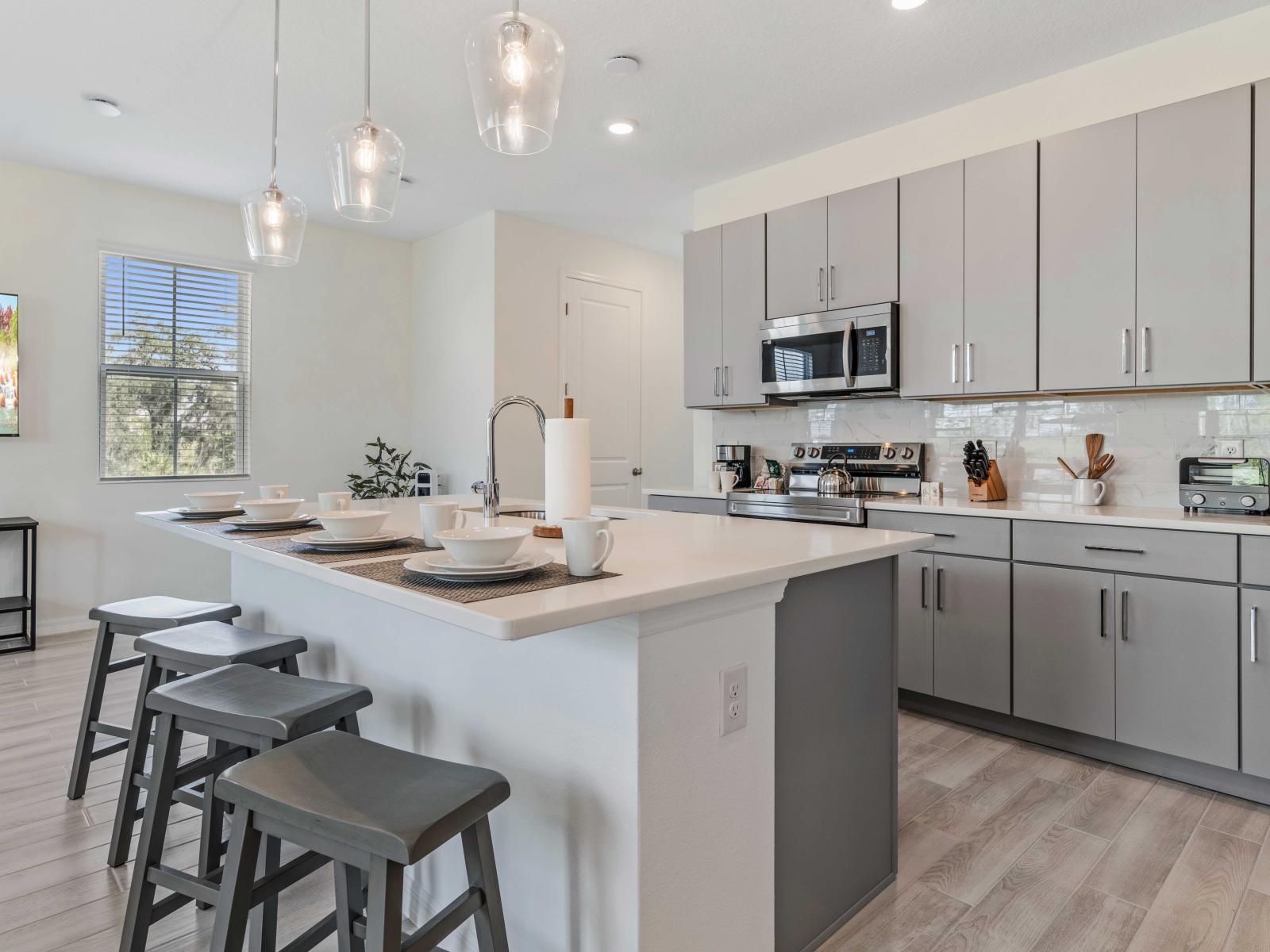 Prepare delicious meals with ease in the beautifully furnished and fully stocked kitchen - Barstool seating, perfect for casual dining and meal prep - Sleek cabinetry and stainless steel appliances, combines style and functionality