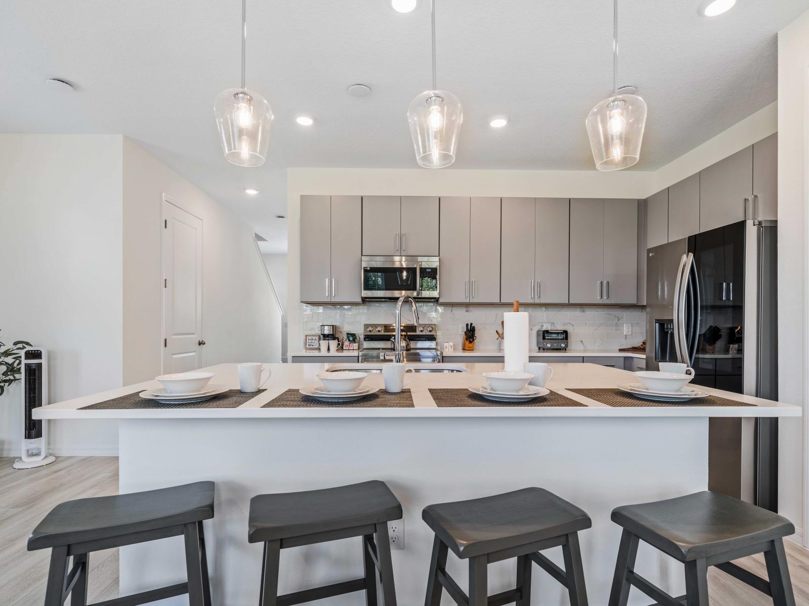 Create culinary masterpieces in the kitchen, thoughtfully designed for both functionality and aesthetics - The area is well-lit with stylish pendant lights that enhance the modern design - This kitchen is perfect for both cooking and entertaining