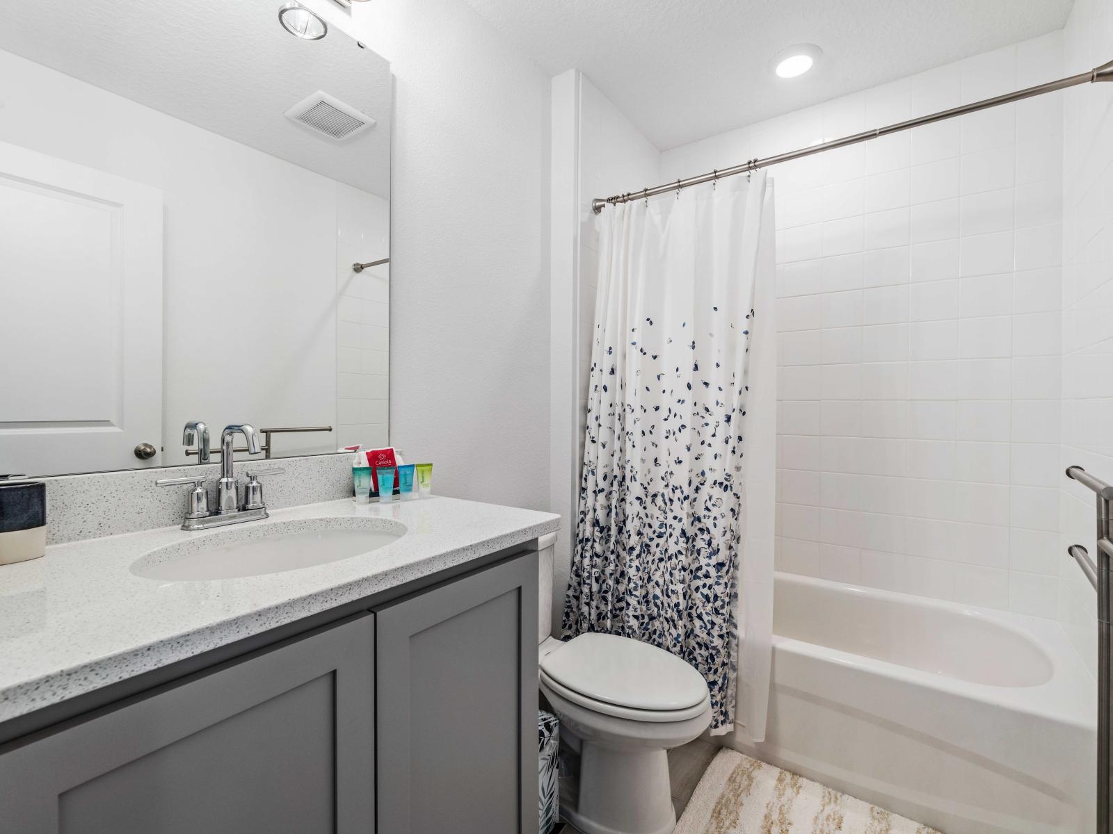 Unwind after a day of adventure in the sleek and stylish bathroom - Featuring a single vanity with sufficient storage and upscale lighting - Bright and clean design with a bathtub and shower combination and necessary toiletries