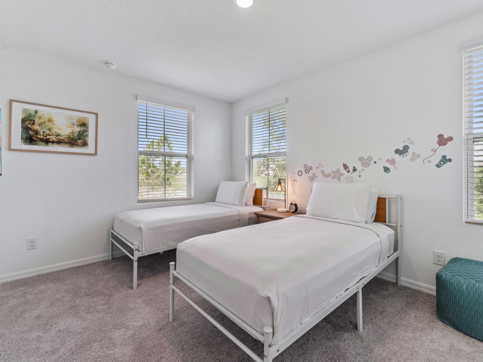 The cozy twin bedroom boasts two single beds with crisp white linens, creating a clean and inviting atmosphere - Playful yet elegant feel, ideal for relaxation - Multiple windows allow plenty of sunlight to fill the room