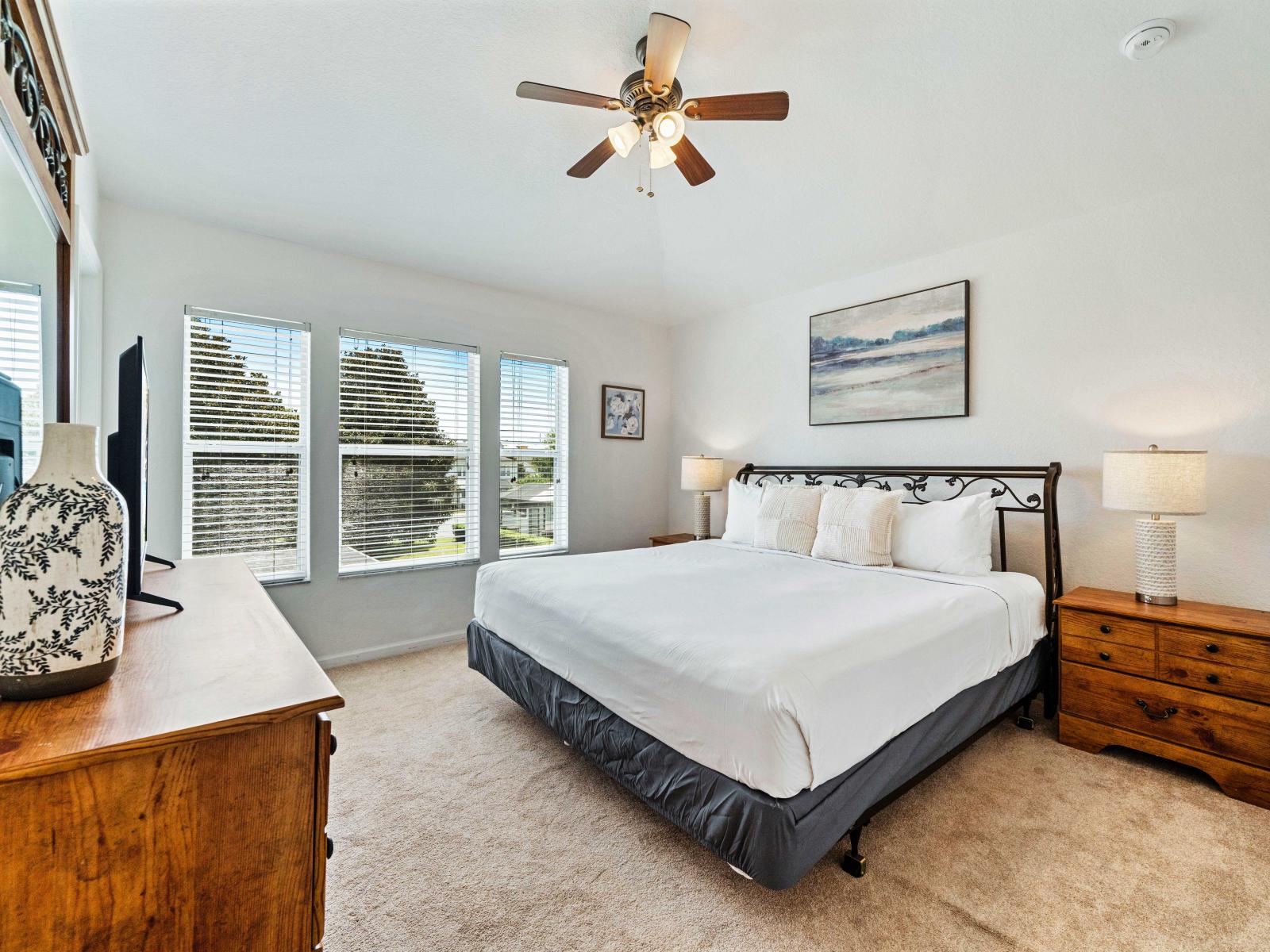 Spacious bedroom featuring a comfortable king-size bed with plush pillows and crisp linens - Natural light from windows enhances the bright and airy atmosphere - Room includes a private bathroom and elegant wooden furniture, creating a cozy retreat