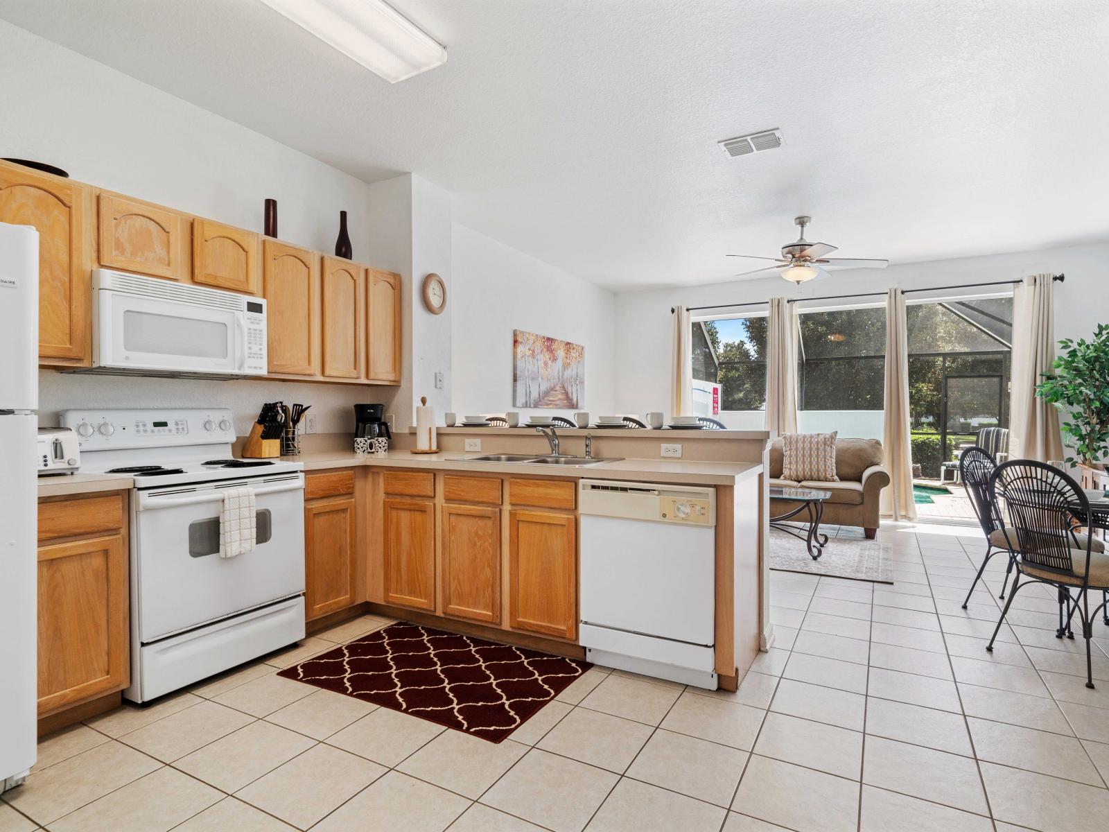 Fully equipped kitchen with modern appliances, refrigerator, oven, and dishwasher - Counter space and wooden cabinets offer plenty of storage - Open layout seamlessly connects to the living and dining areas, perfect for socializing and entertaining