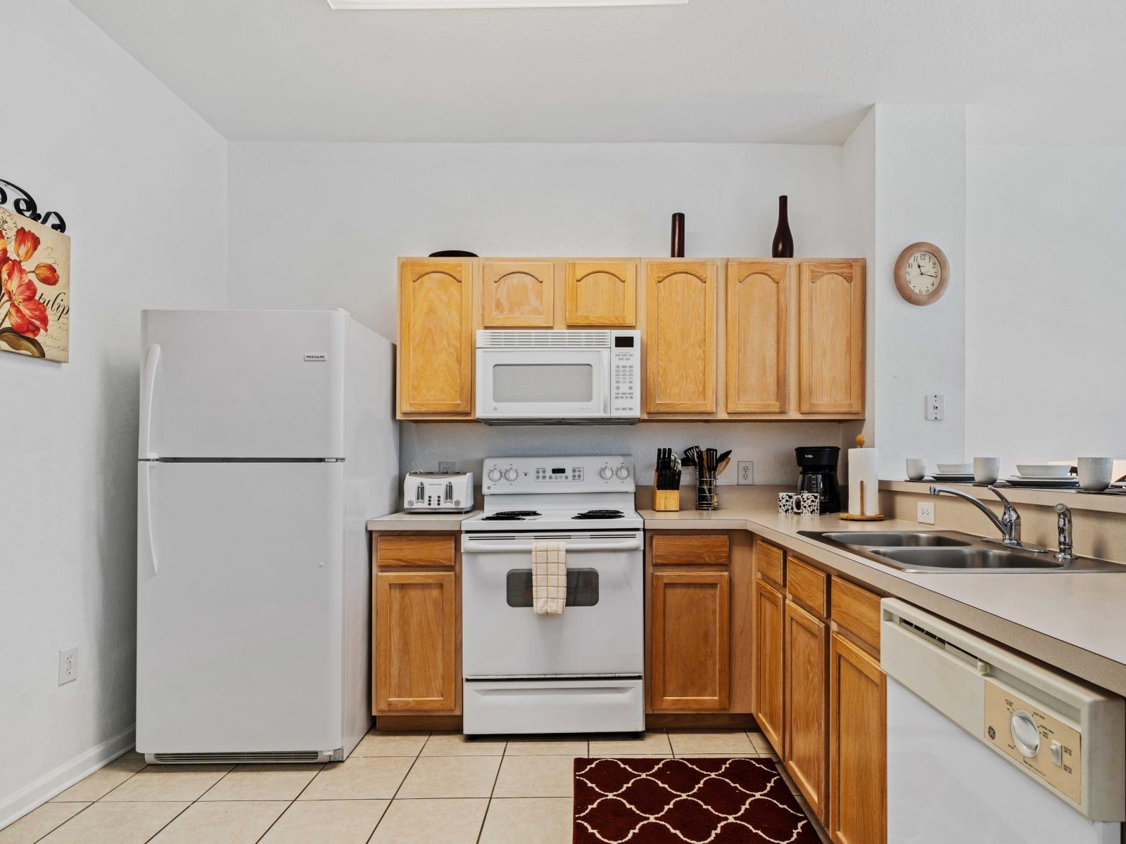 Well-appointed kitchen featuring essential appliances - Sleek wooden cabinets and countertops provide both style and functionality - Decorative touches and practical layout enhance the cooking and dining experience