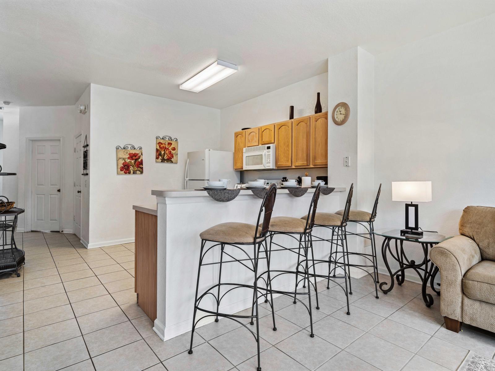 Spacious kitchen with a breakfast bar featuring seating for three, perfect for casual dining - Bright and open layout, seamlessly connecting to the living area for easy interaction - Functional design with counter space, ideal for meal preparation