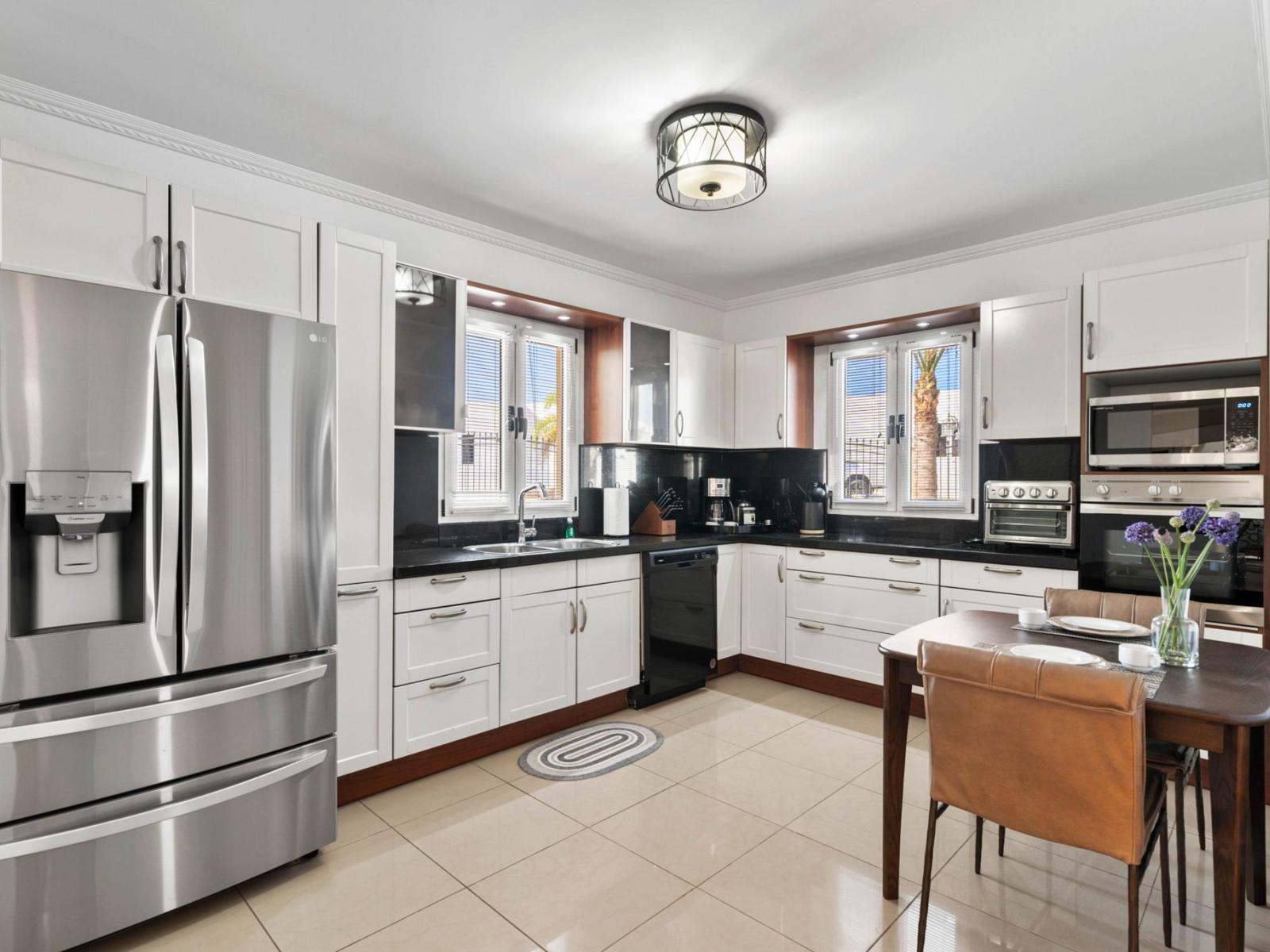 - Modern kitchen featuring high-end stainless steel appliances and crisp white cabinetry - Sunlit space with large windows, creating a bright and welcoming environment - Enjoy your morning coffee in the cozy breakfast nook, perfect for casual dining