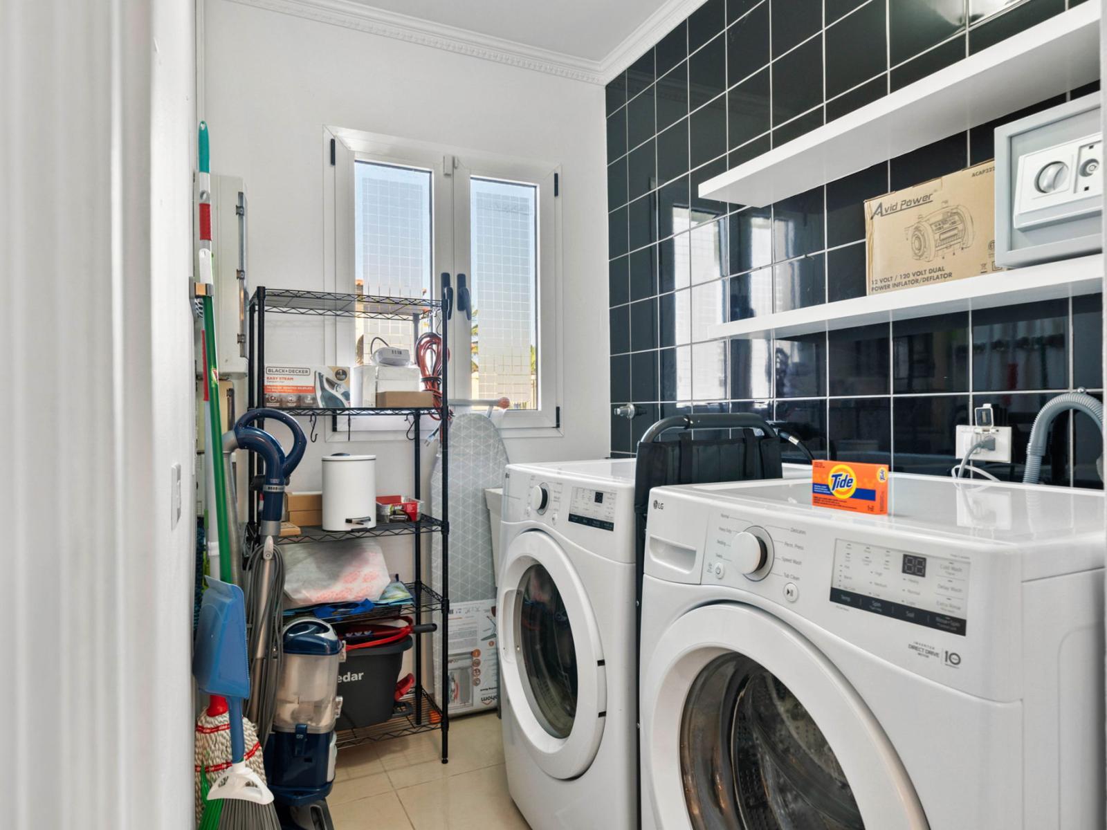 - Efficient laundry room with modern washer and dryer units for easy laundry tasks - Plenty of shelving and storage keep supplies organized and accessible - Natural light and a sleek, functional design make this space both practical and pleasant