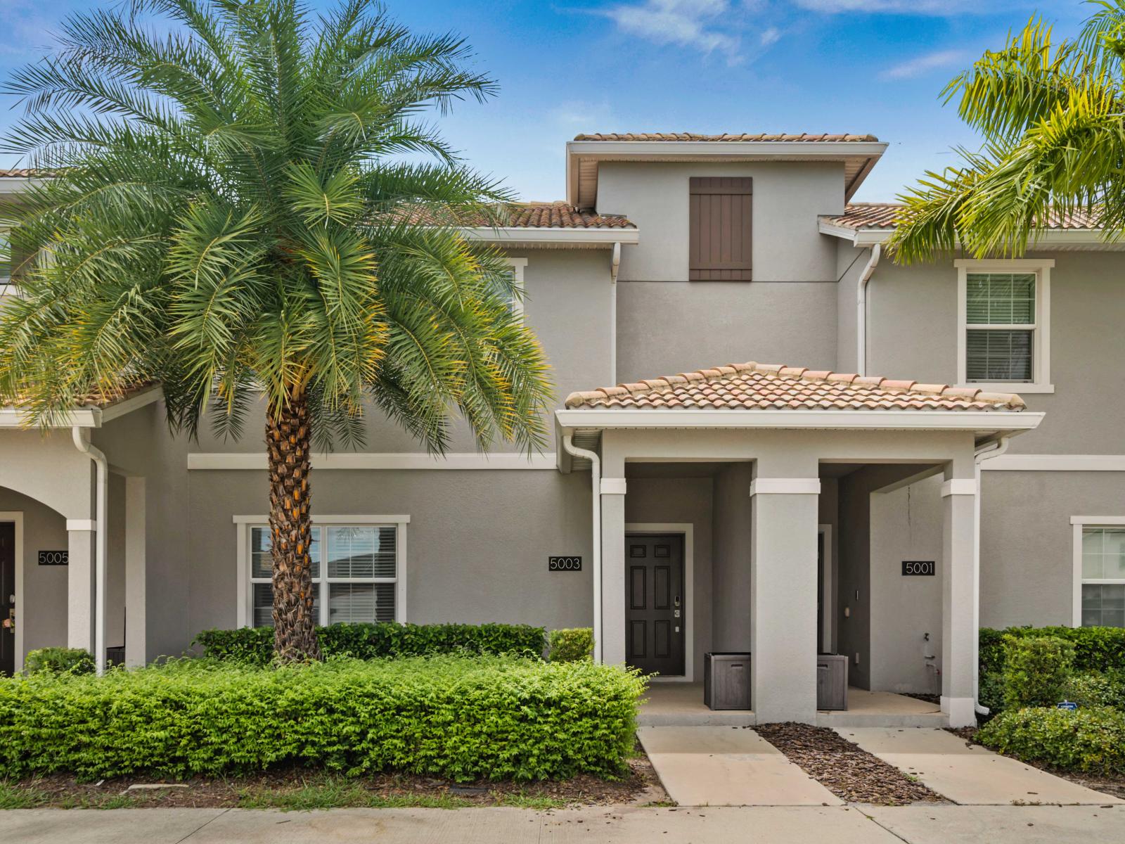 Modern home exterior with tropical landscaping and a welcoming entrance.