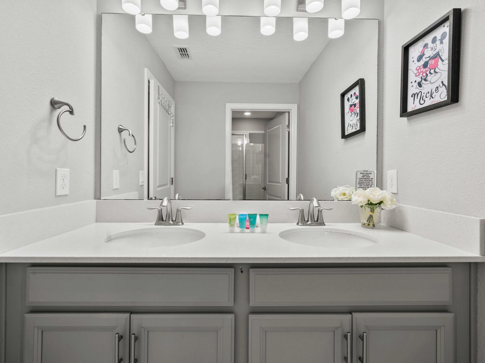 - Bathroom features a stylish double vanity and a convenient walk-in shower - Modern and bright, this bathroom offers plenty space and functionality for your daily routine - Thoughtful touches like Disney-themed decor add a playful charm to the space