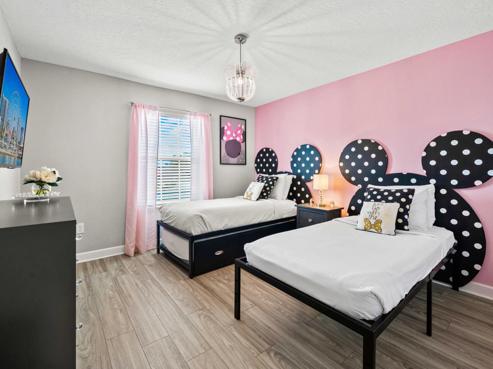 - Two single beds with playful Disney decor, ideal for kids or Disney enthusiasts - Bright and cheerful, featuring Minnie Mouse-inspired headboards and soft pink accents - A cozy, imaginative space with a wall-mounted TV for added entertainment