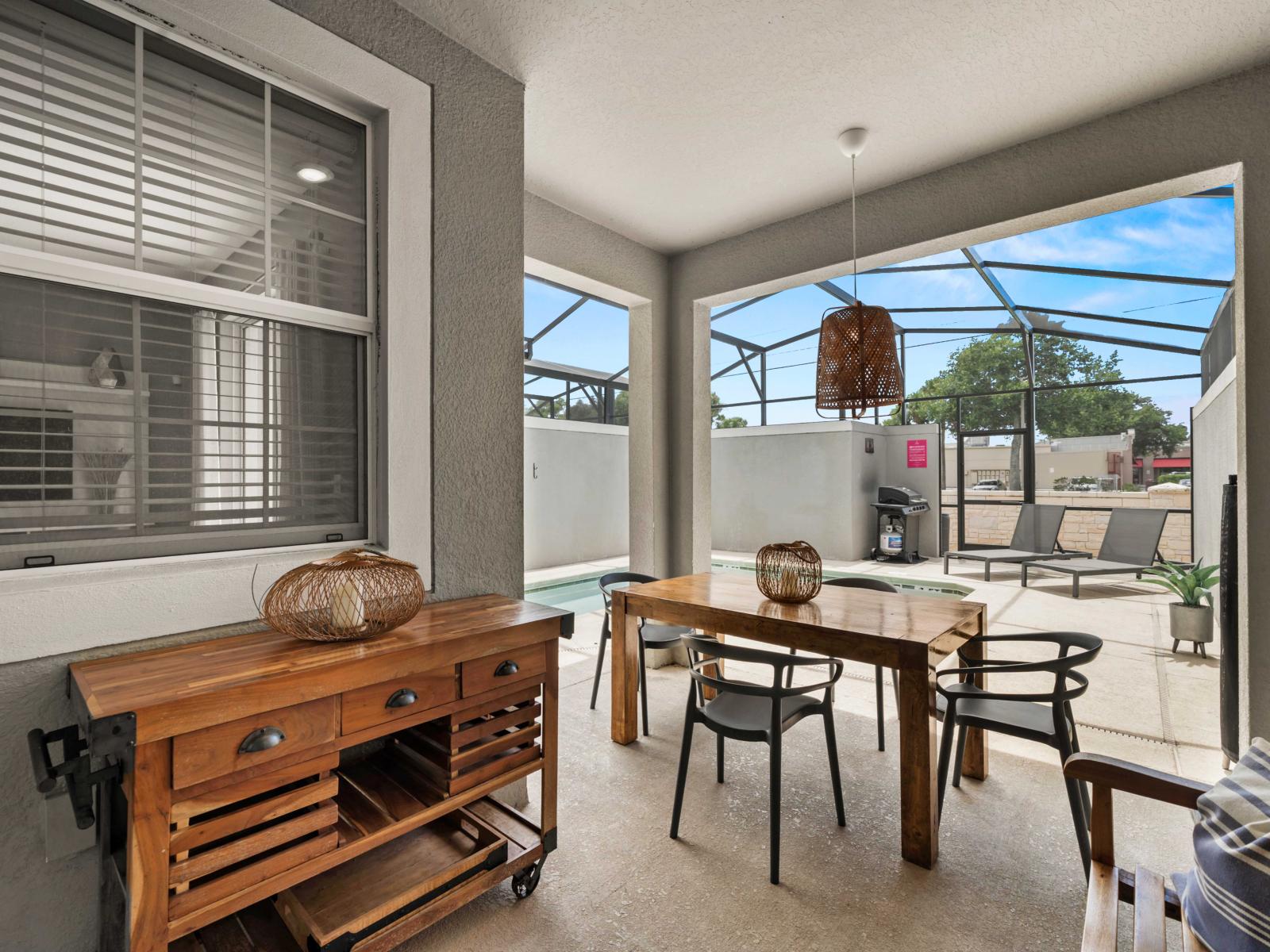 - Outdoor dining area with a rustic wooden table, perfect for enjoying meals by the pool - Relax in this shaded space, ideal for casual gatherings or a quiet retreat - Seamlessly blend indoor and outdoor living in this inviting, open-air setting