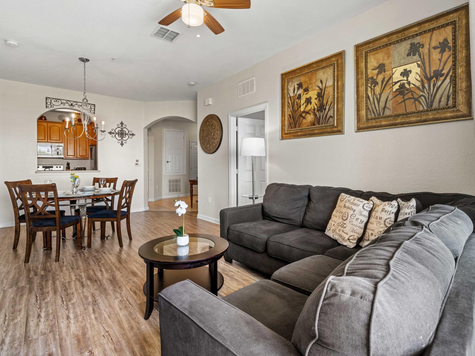 - Comfortable living area with a cozy gray sofa perfect for unwinding after a long day - Dining area conveniently located near the kitchen make it easy to enjoy meals - Decorated with stylish artwork & elegant furniture creating a inviting experience