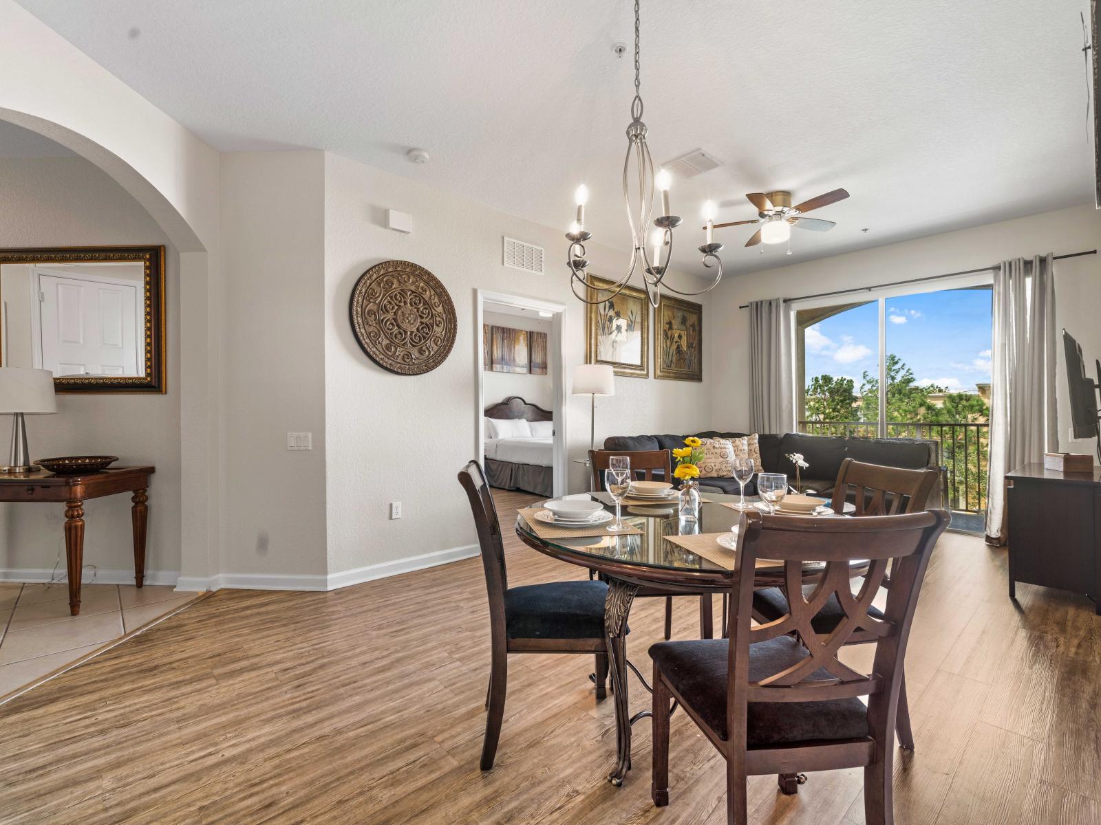 - Open-concept dining area with a round table & plush chairs perfect for enjoying meals - Living room & dining area flow seamlessly creating a connected environment - Elegant touches like chandelier and wall decor adds charm to the overall space