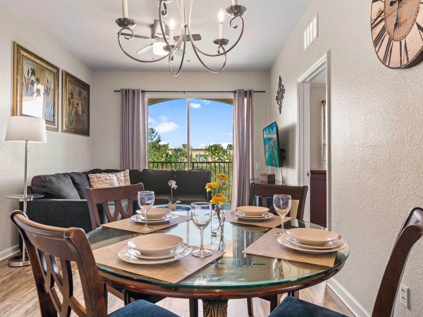 - Stylish dining area with a glass-top table set for four creating a perfect spot for meals - Dining space is beautifully illuminated by a modern chandelier adding elegance to the space - Open layout keeps the dining &living areas connected and cozy