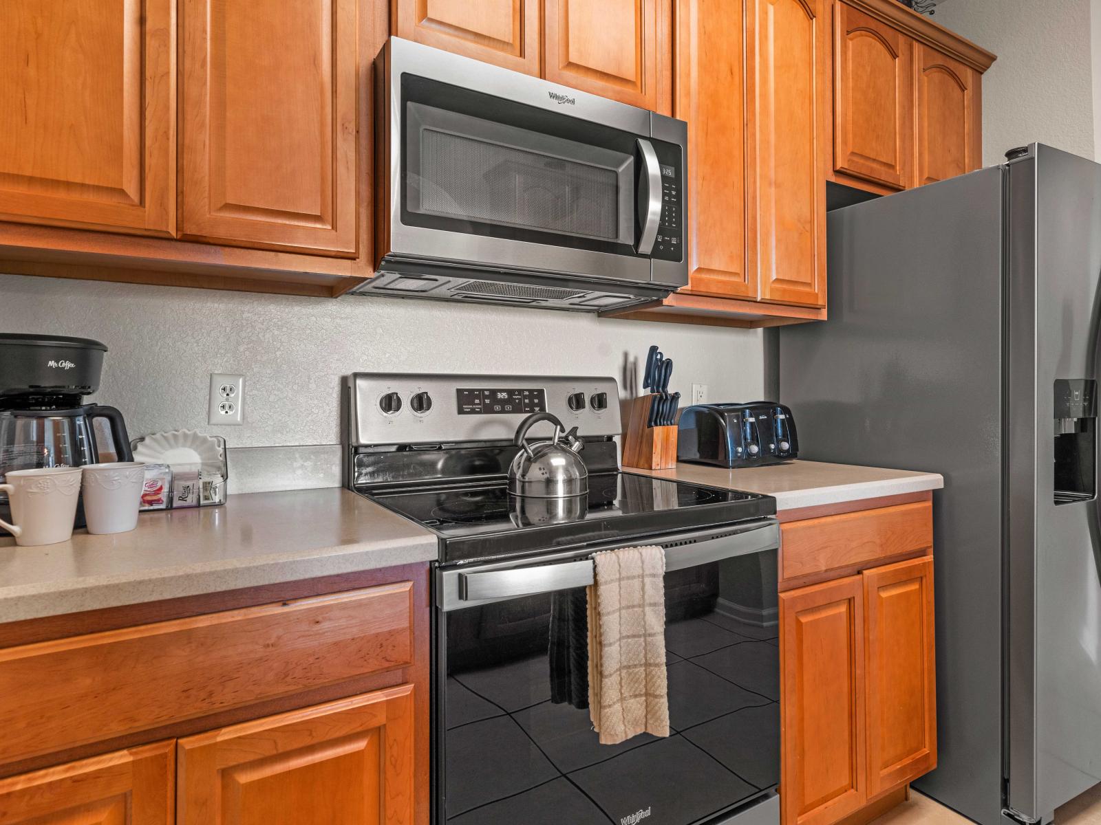 - Fully equipped kitchen with modern appliances including a stainless steel refrigerator& microwave - Generous countertop space provides easy access to kitchen essentials - Wooden cabinetry adds a classic touch and provides plenty of storage