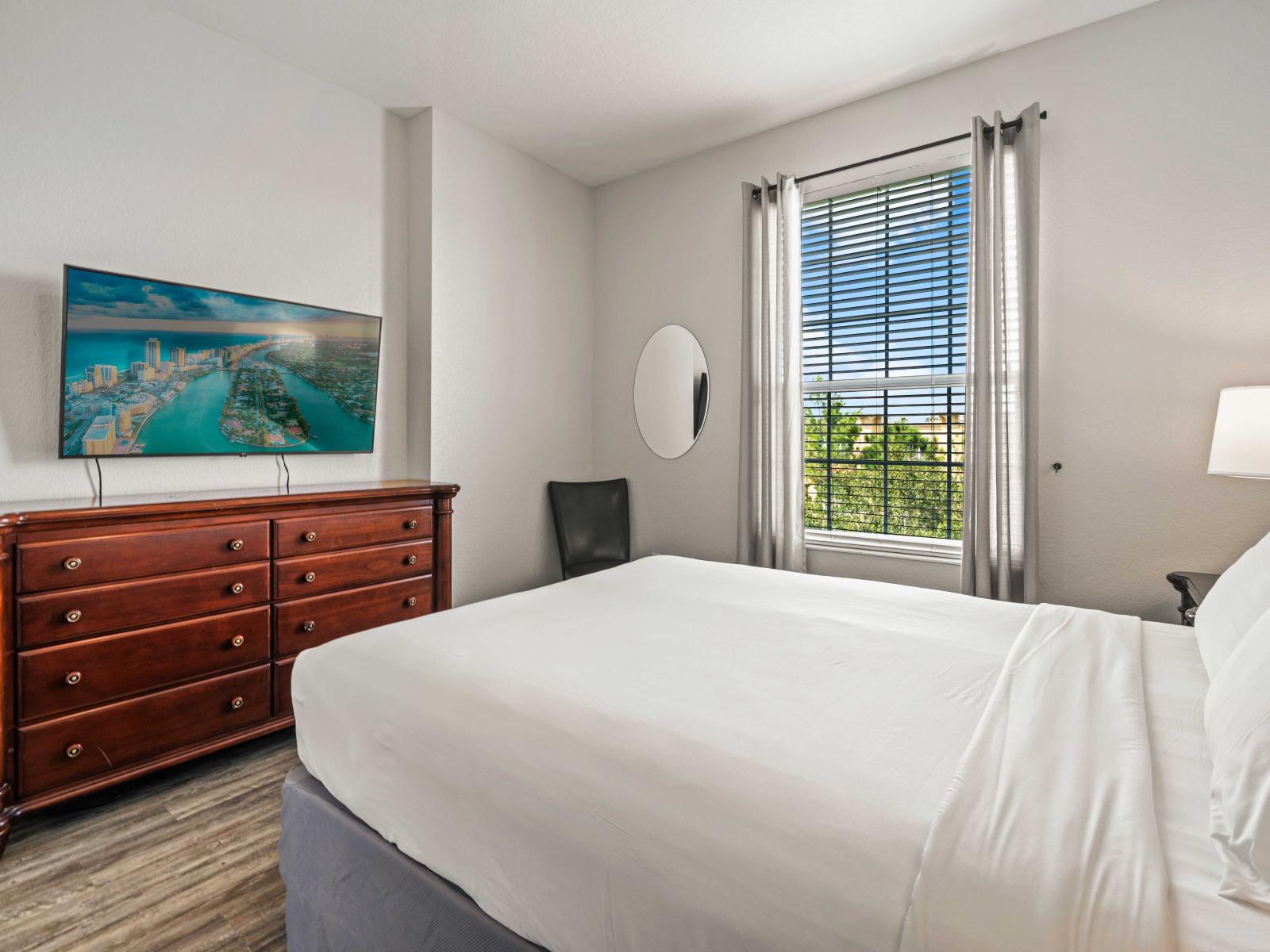 - Beautiful bedroom with a queen-sized bed, perfect for a restful night's sleep - Equipped with a large dresser and a smart TV for entertainment and storage - A bright window offers a pleasant view and natural light along with elegant decor