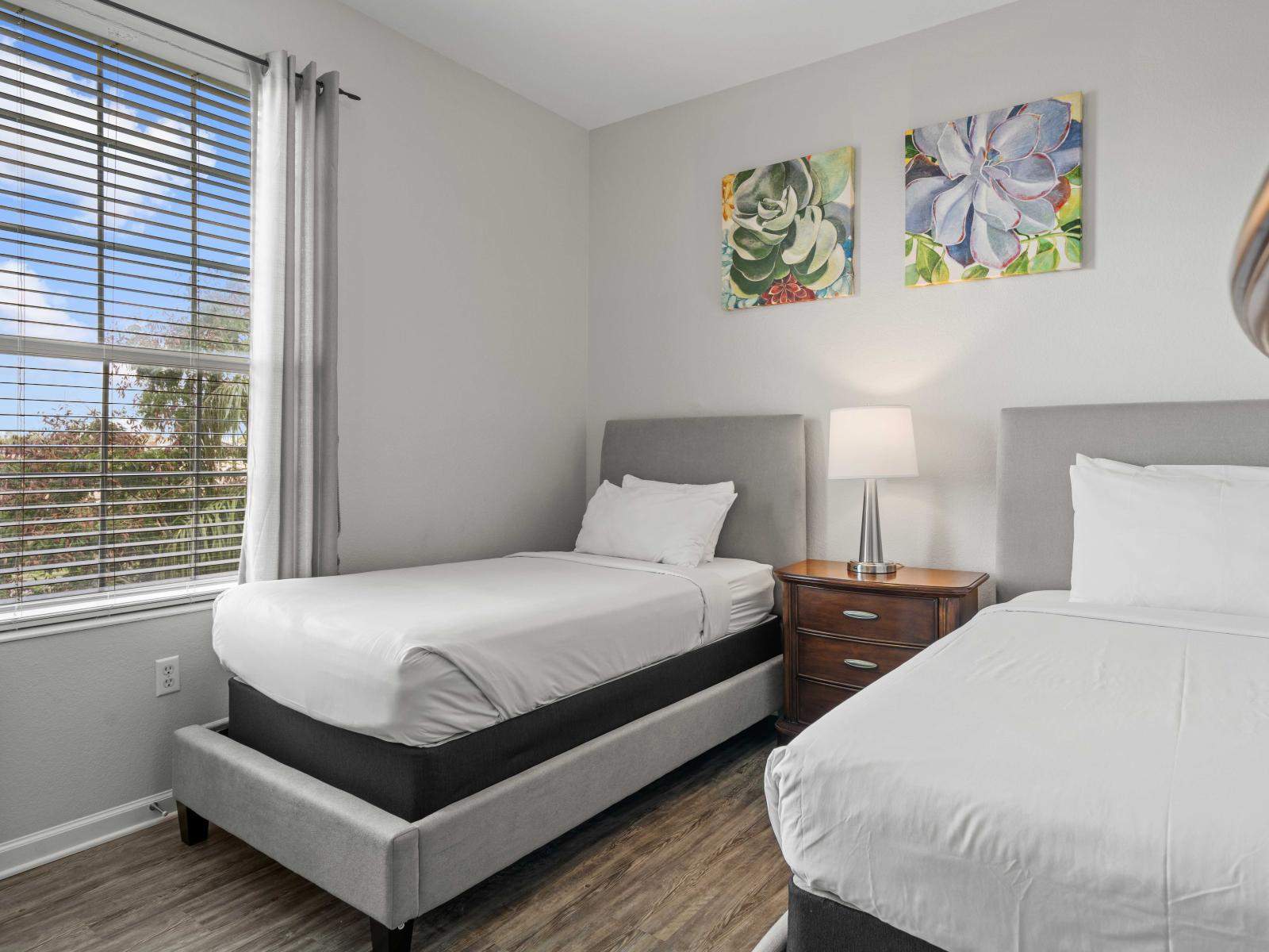 - Elegant bedroom with two single beds, ideal for accommodating guests or children - Large window allows natural light to brighten the room with side table between the beds - Features a private bathroom, offering added convenience and privacy