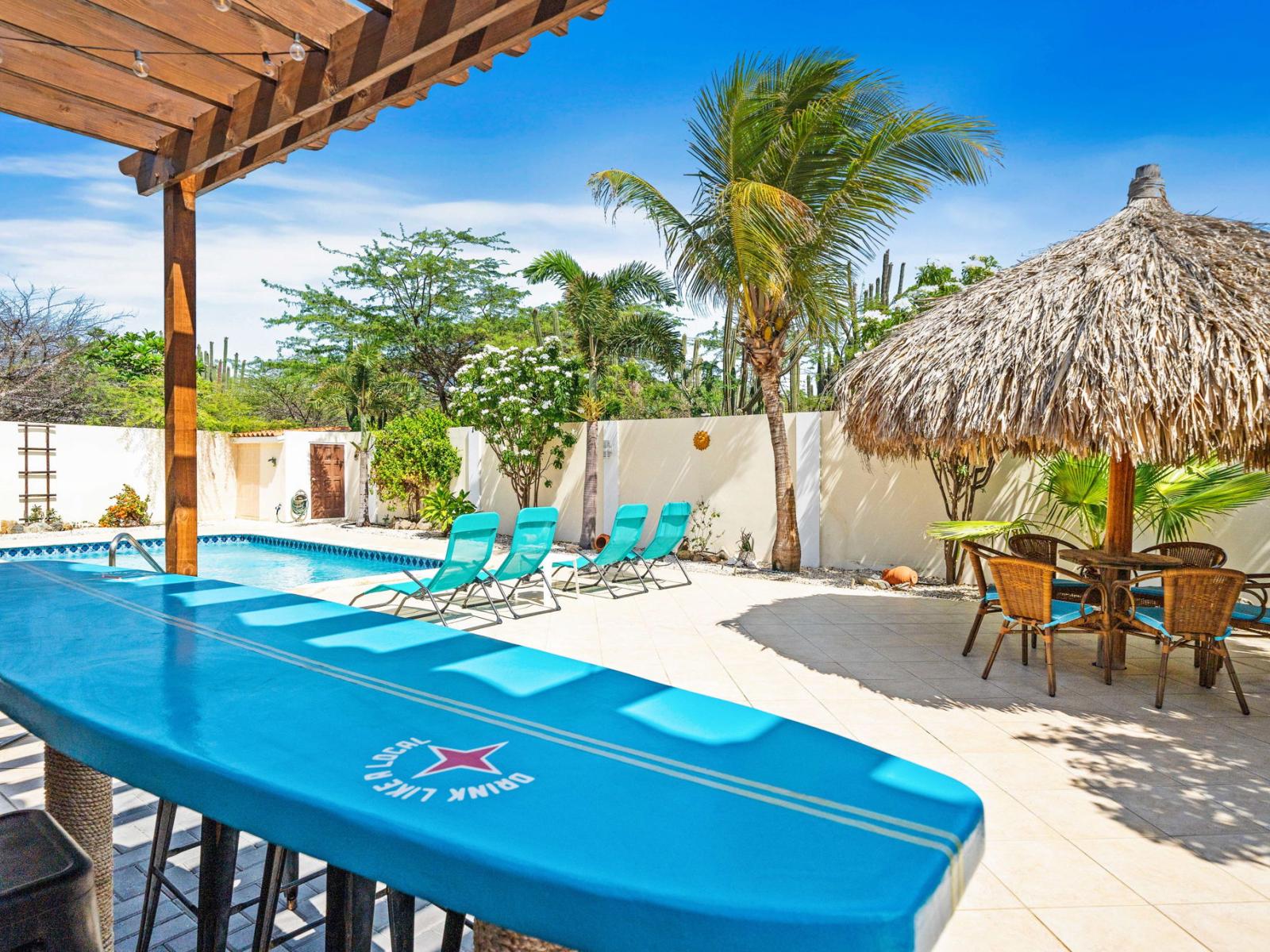 Enjoy a refreshing dip in the pool surrounded by lush greenery and clear blue skies - Featuring plenty of seating weather lounge in the sun or sit under the shade of gazebo - Perfect for unwinding, with a unique surfboard bar table