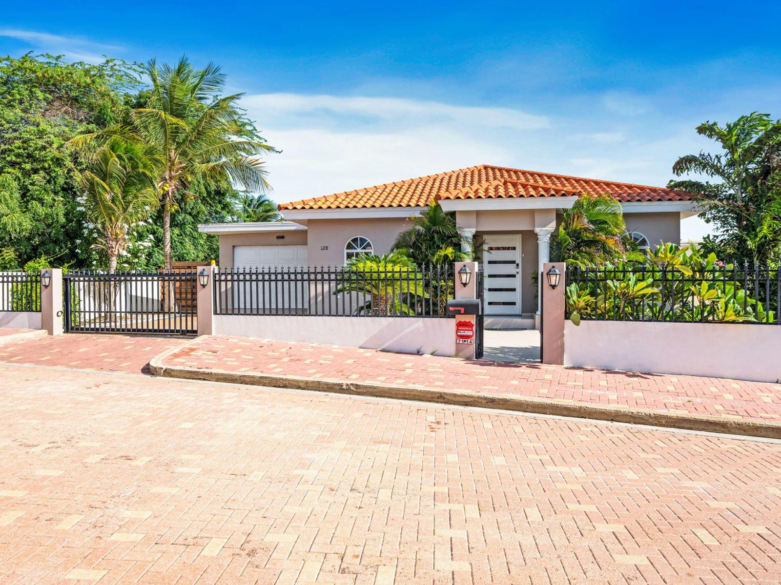 Beautiful home with a charming terracotta roof, secure gated entrance - Lush tropical landscaping, enjoy the serene environment and picturesque surroundings - "Start your journey to relaxation with a seamless entry