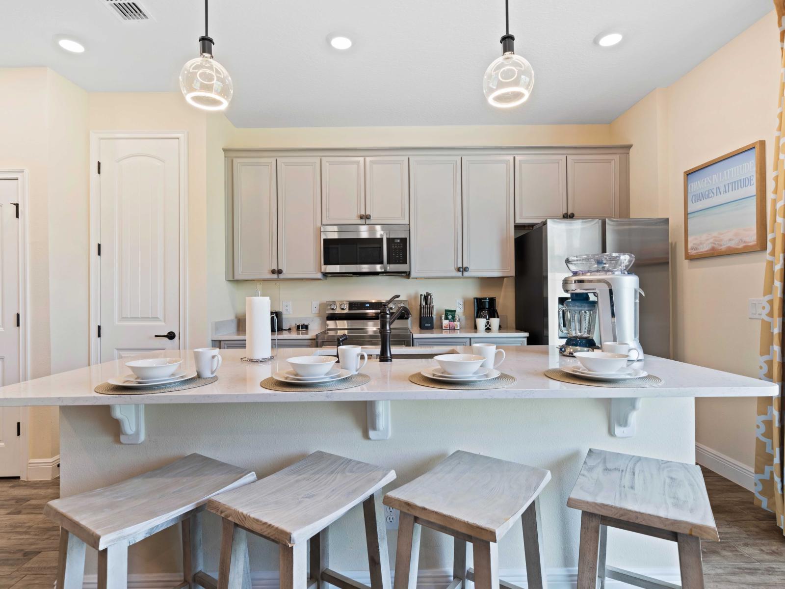 Modern kitchen featuring sleek stainless steel appliances and elegant gray cabinetry - Spacious breakfast bar with four rustic stools, perfectly set with white dishware, ready for a cozy meal - Large patterned curtains bring warmth and style