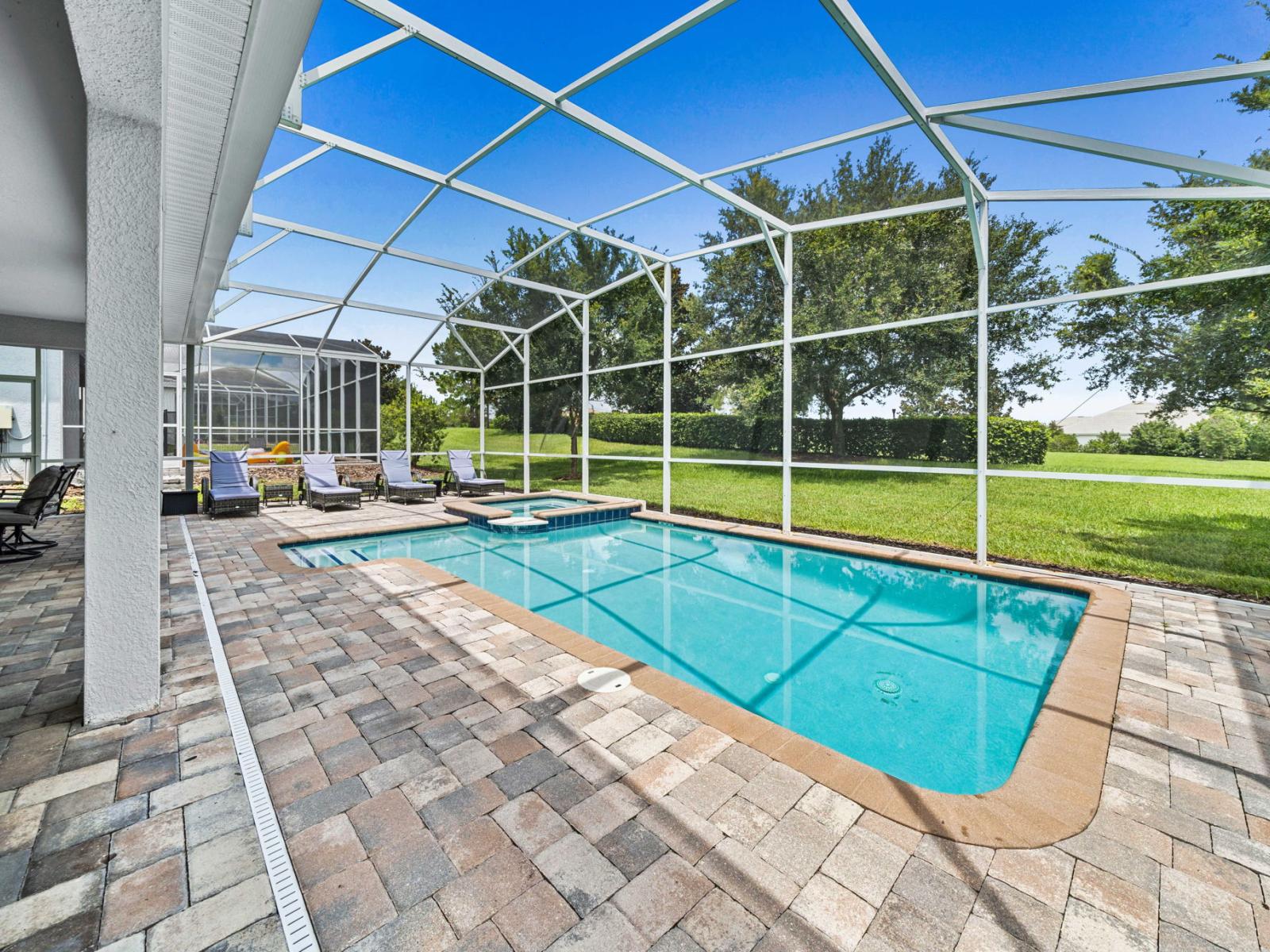 - Enjoy a private, screened-in pool area perfect for relaxation and entertainment - Several lounge chairs are available for sunbathing and unwinding by the poolside - Surrounded by lush greenery, providing a serene and picturesque outdoor space