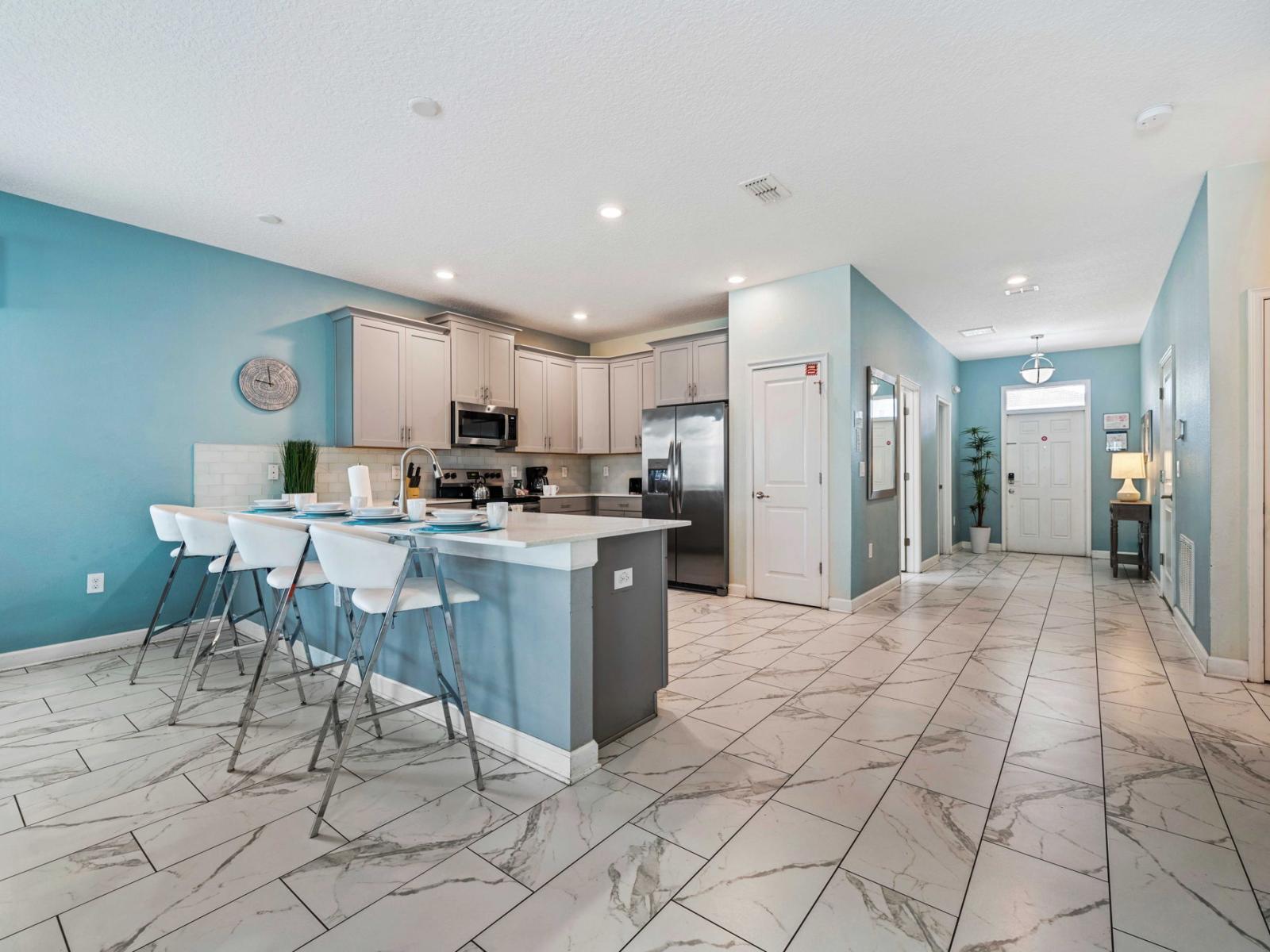 - Contemporary kitchen with stainless steel appliances and a sleek design - Large island with bar seating, perfect for casual dining or socializing while cooking - Bright and airy space with plenty of natural light and elegant tiled flooring