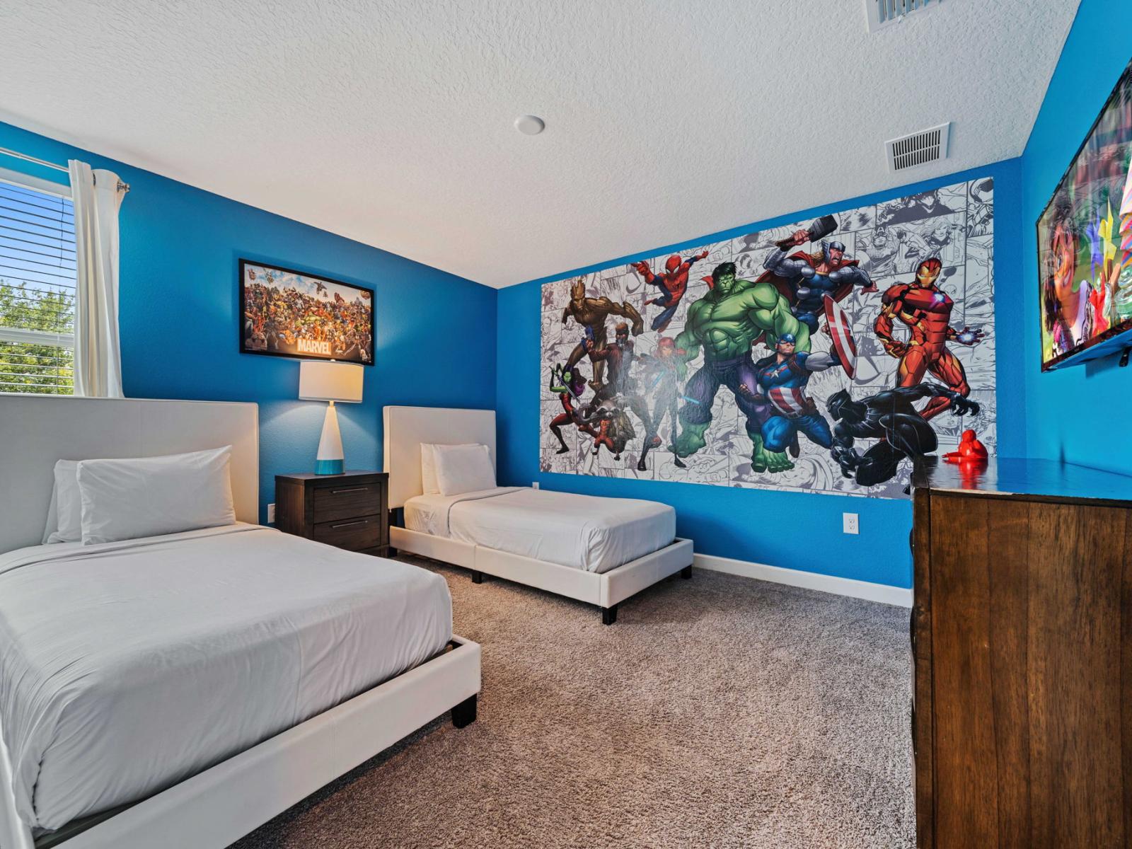 - Bedroom features twin beds with Marvel theme and smart TV - A large, colorful superhero mural, adding a playful and energetic touch to the room - Wall-mounted TV provides entertainment, making it a perfect retreat for kids or superhero enthusiasts