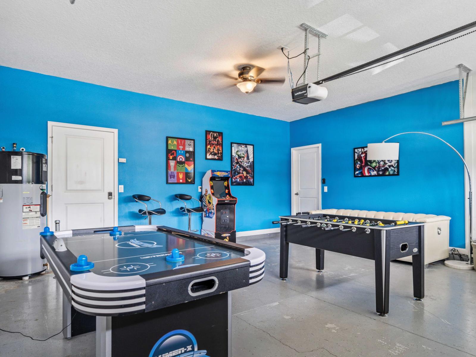 - The game room bright blue walls create a lively and energetic atmosphere - Equipped with air hockey & foosball tables, designed for friendly competition - Arcade machine adds touch of nostalgia, while modern wall decor enhances overall experience