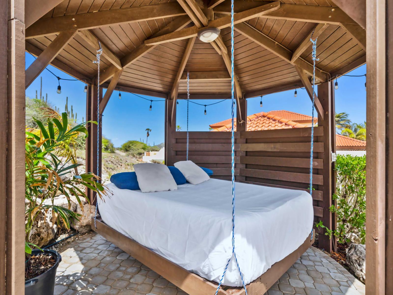 Experience the ultimate relaxation with our outdoor hanging bed under the gazebo - Nestled in a serene setting, ideal spot to unwind and soak in the tranquility - Feel the cool breeze and enjoy the picturesque surroundings as you relax in comfort