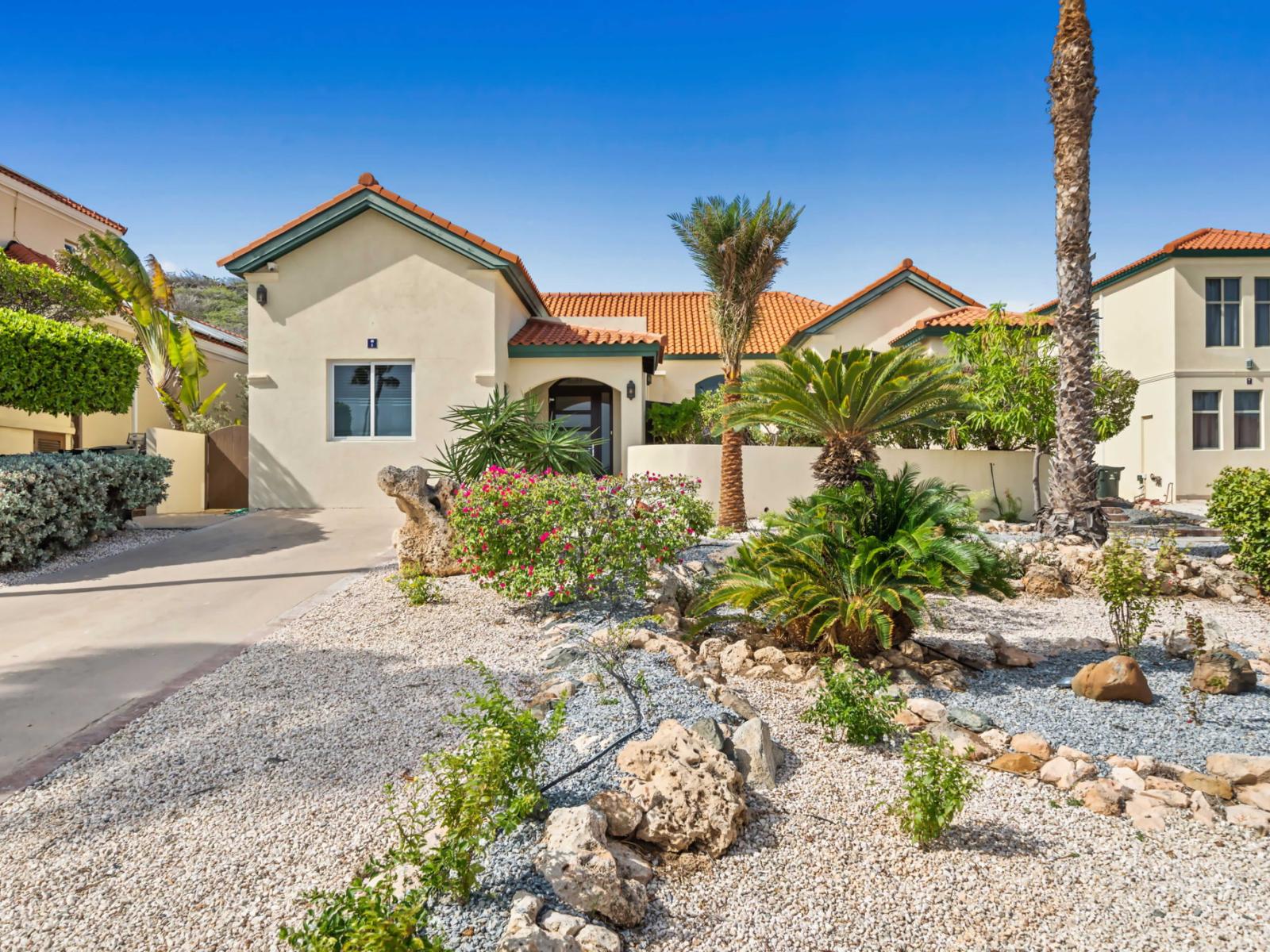 Charming home with terracotta roofs and a desert-inspired garden, offering a tranquil and inviting atmosphere.