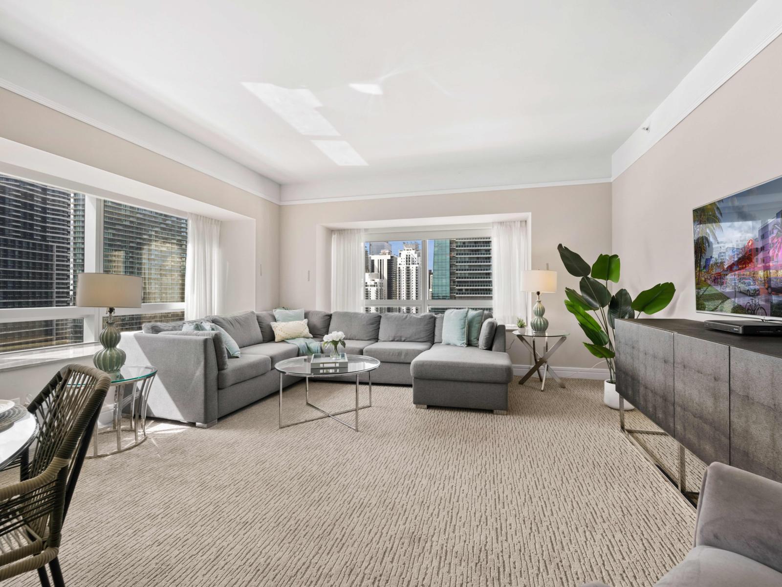 Experience ultimate comfort in a spacious living room designed for relaxation - Comfortable, stylish sectional sofa and large flat-screen TV for entertainment - Space is ideal for enjoying the vibrant cityscape from the comfort of your home