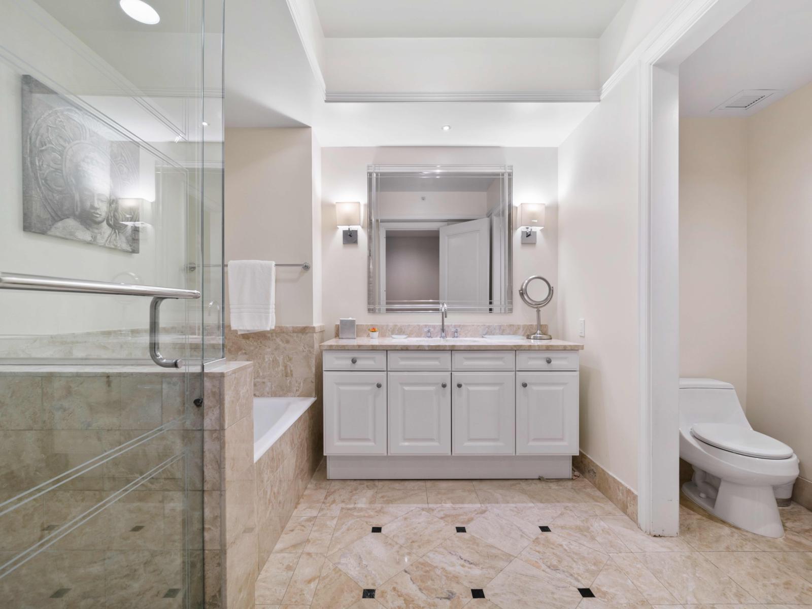 - Indulge in the marble-tiled bathroom featuring a spacious walk-in shower and a separate soaking tub - Dual vanities provide plenty of space, ensuring a comfort and convenience - Meticulously designed, this bathroom offers a spa-like retreat