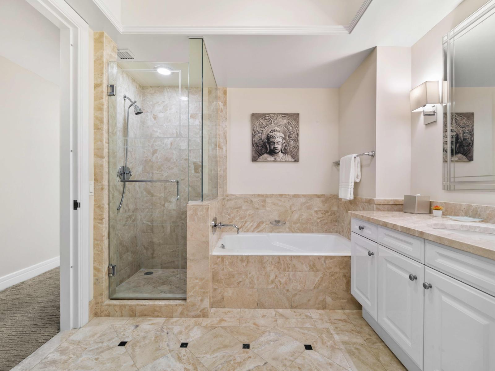 - Indulge in a luxurious bathroom with a glass shower and soaking tub, ideal for unwinding - Elegant marble finishes enhance the sophisticated ambiance - Spacious vanity offers plenty of room for your essentials, ensuring a comfortable experience