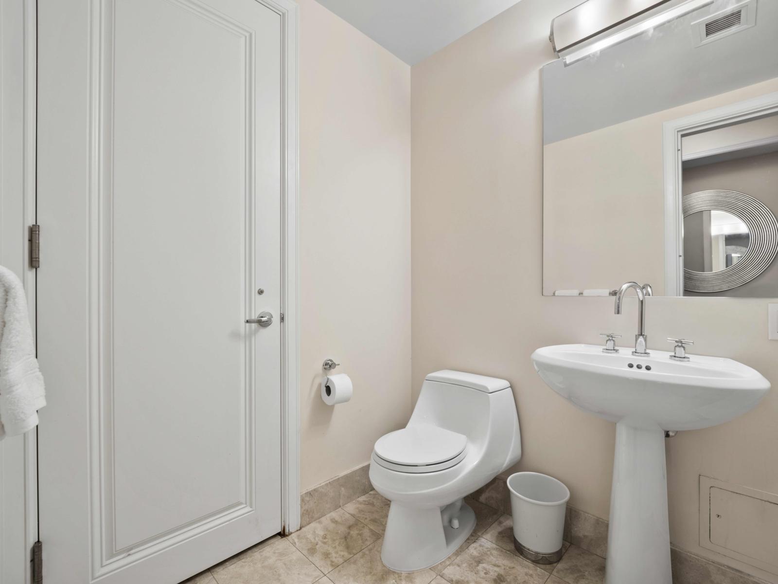 - Simple and elegant half-bathroom featuring a sleek pedestal sink and modern fixtures - Clean design offers convenience with a touch of style - Thoughtfully designed with easy access, this bathroom combines functionality with a minimalist aesthetic