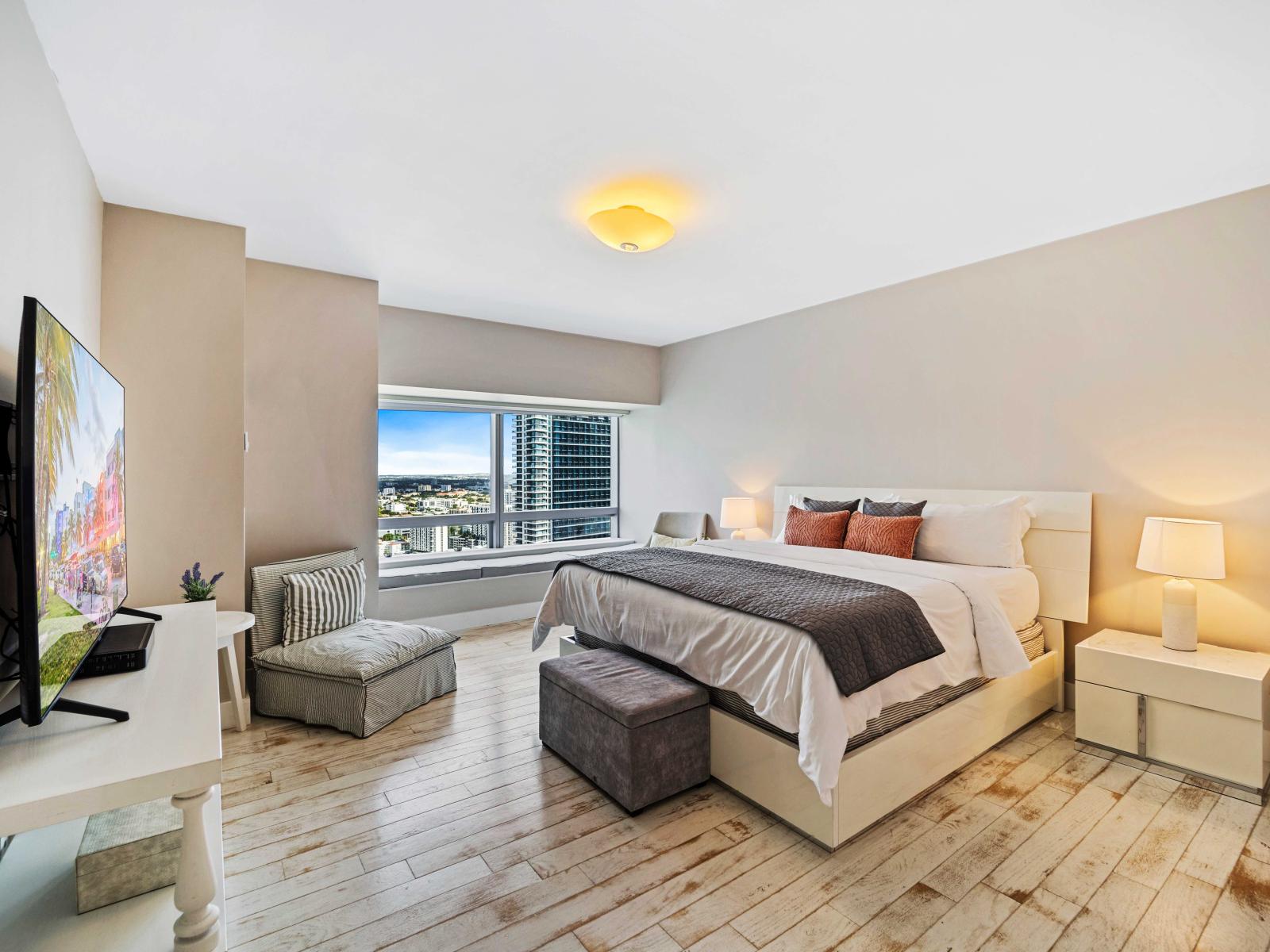 - Spacious bedroom featuring a comfortable king-sized bed with plush linens  - Large windows offering stunning city views, allowing natural light to the room - Equipped with a Smart TV and cozy seating space, perfect for enjoying your favorite shows