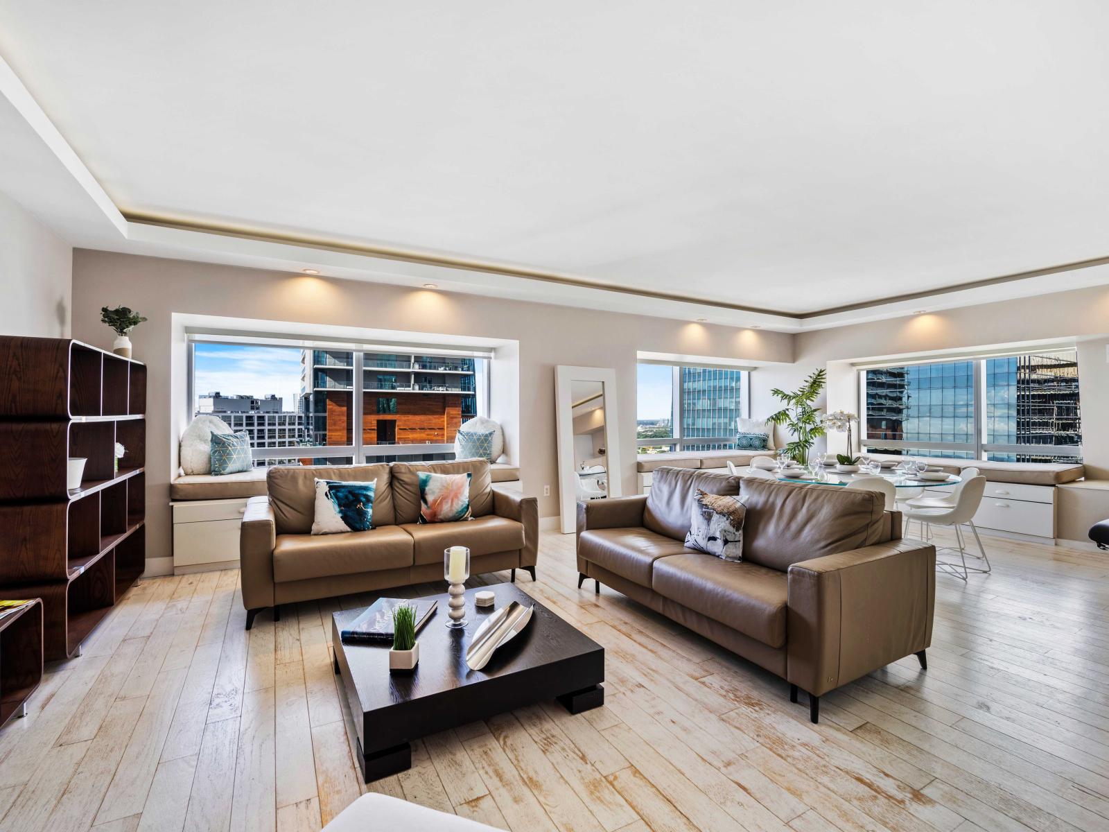 -  Elegantly designed living area with cozy seating, perfect for relaxation - Large windows provide natural light and offer stunning city views enhancing the ambiance - Modern decor with cozy accents, creating comfortable atmosphere for your stay