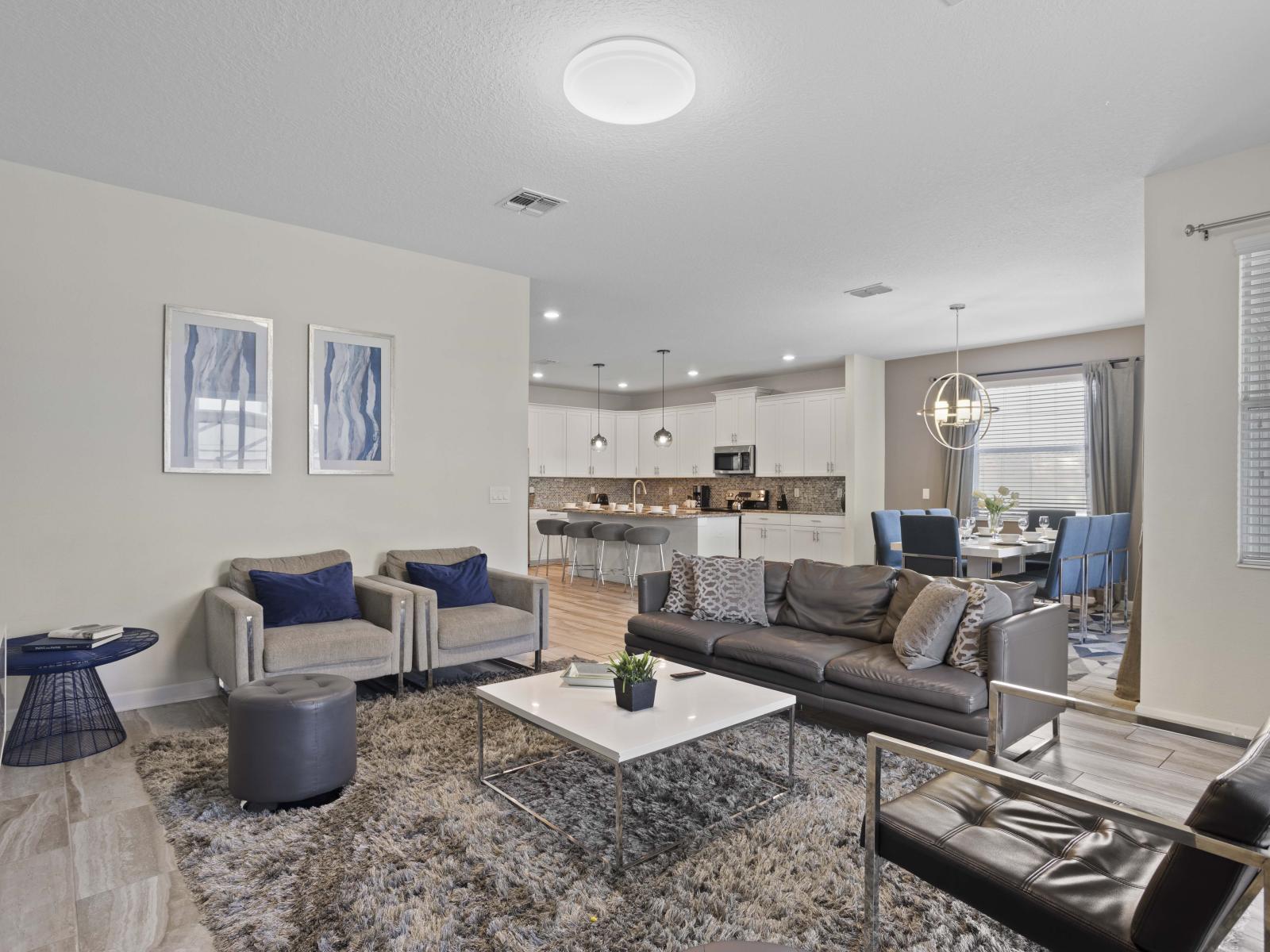 - Indulge in comfort of this spacious living area connected to an open kitchen - Comfortable seating and modern furnishings create a perfect gathering space - Ideal for socializing, with easy access to the kitchen and dining space