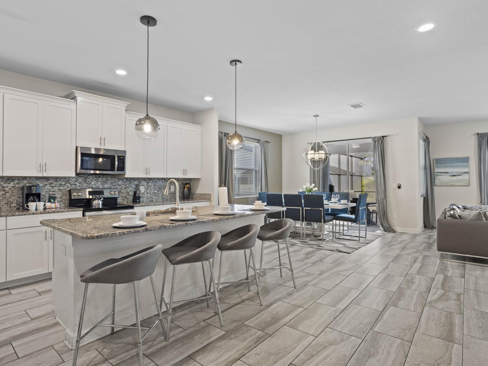 - Cook and dine in this open-concept kitchen with modern appliances - Large kitchen island with bar seating perfect for casual meals or conversations - Seamless flow from kitchen to dining area, ideal for entertaining